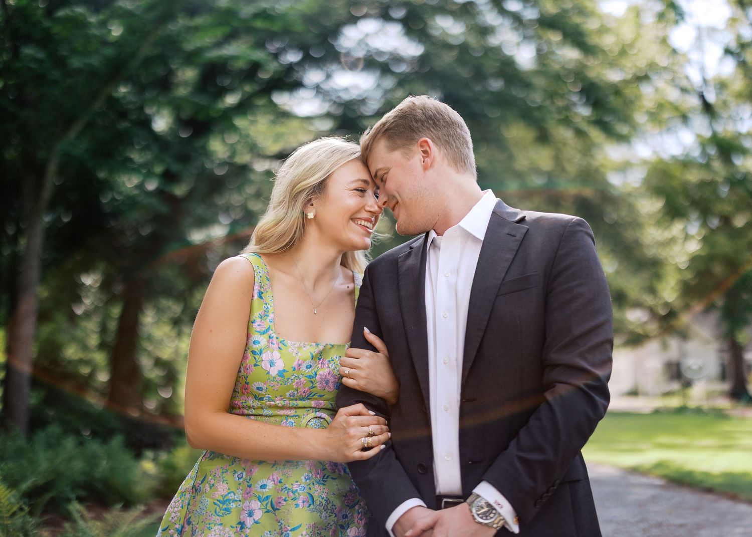 Couple sharing intimate moment on garden path surrounded by greenery.