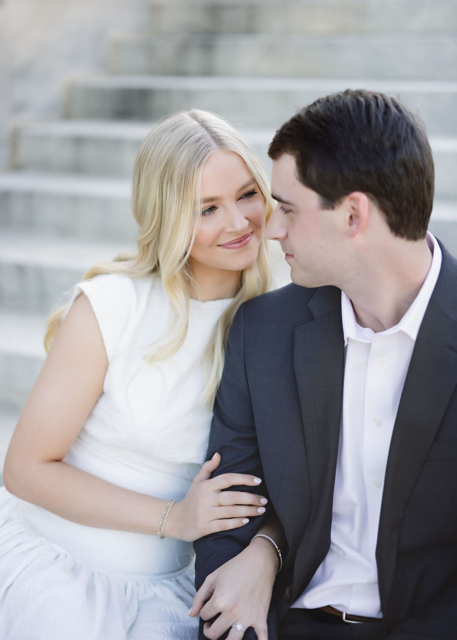 A tender moment between a couple in formal wear on stone steps.