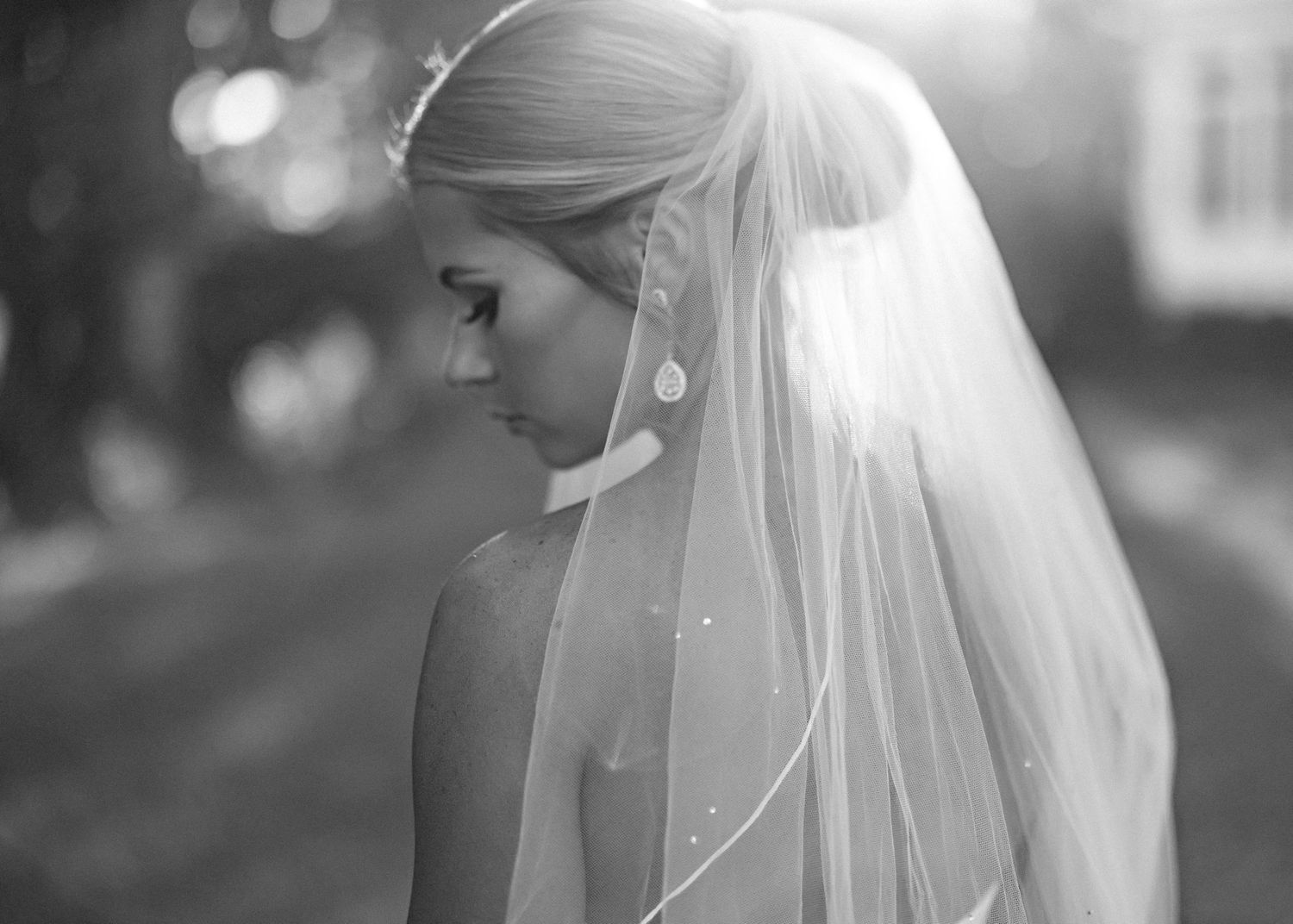 A black and white photo series of a bride in her wedding veil during an outdoor ceremony.