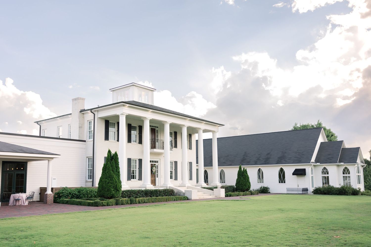 Panoramic view of a grand white wedding venue with manicured lawns.