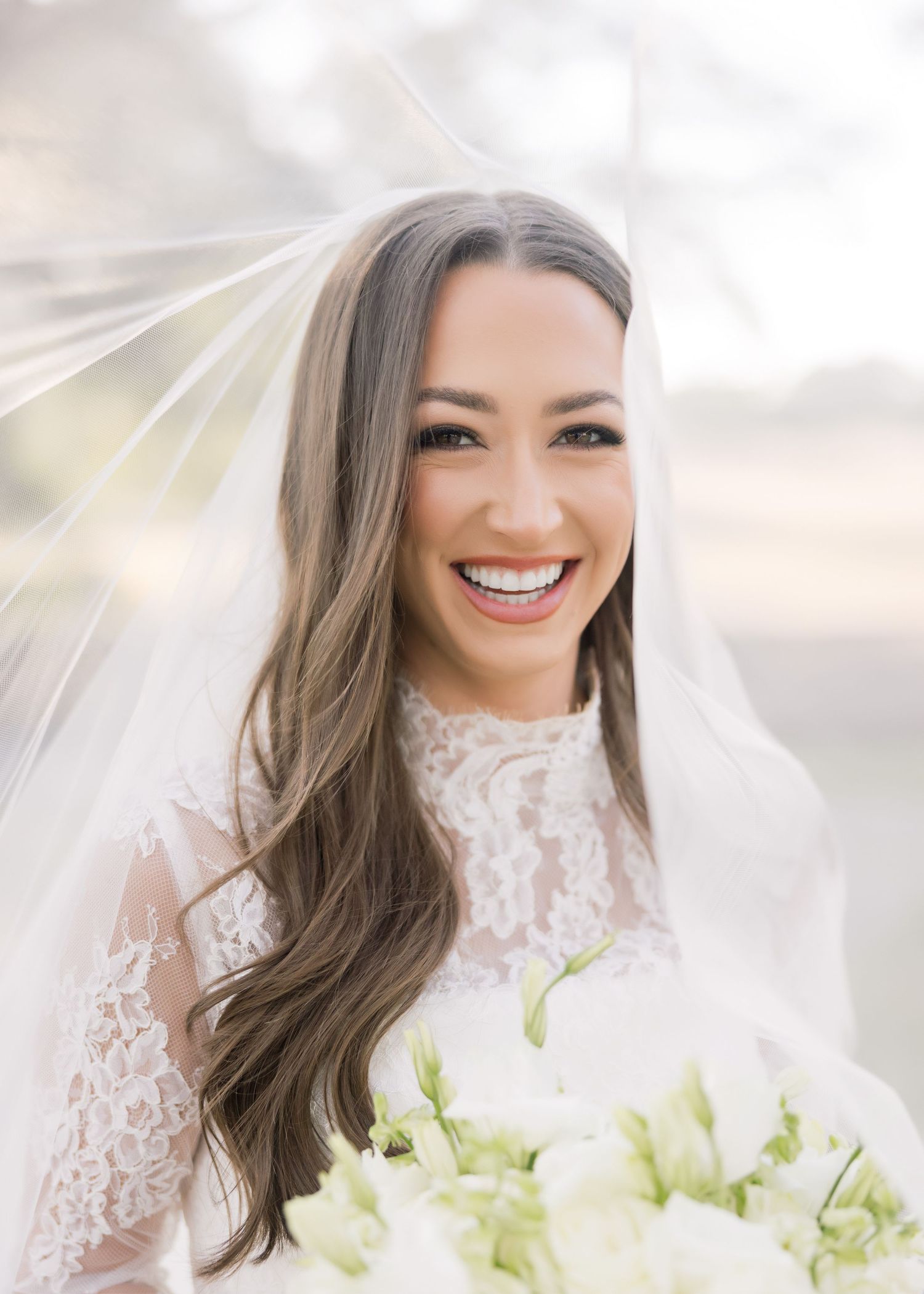 Bridal portrait series with delicate lace details and white bouquet against natural lighting.