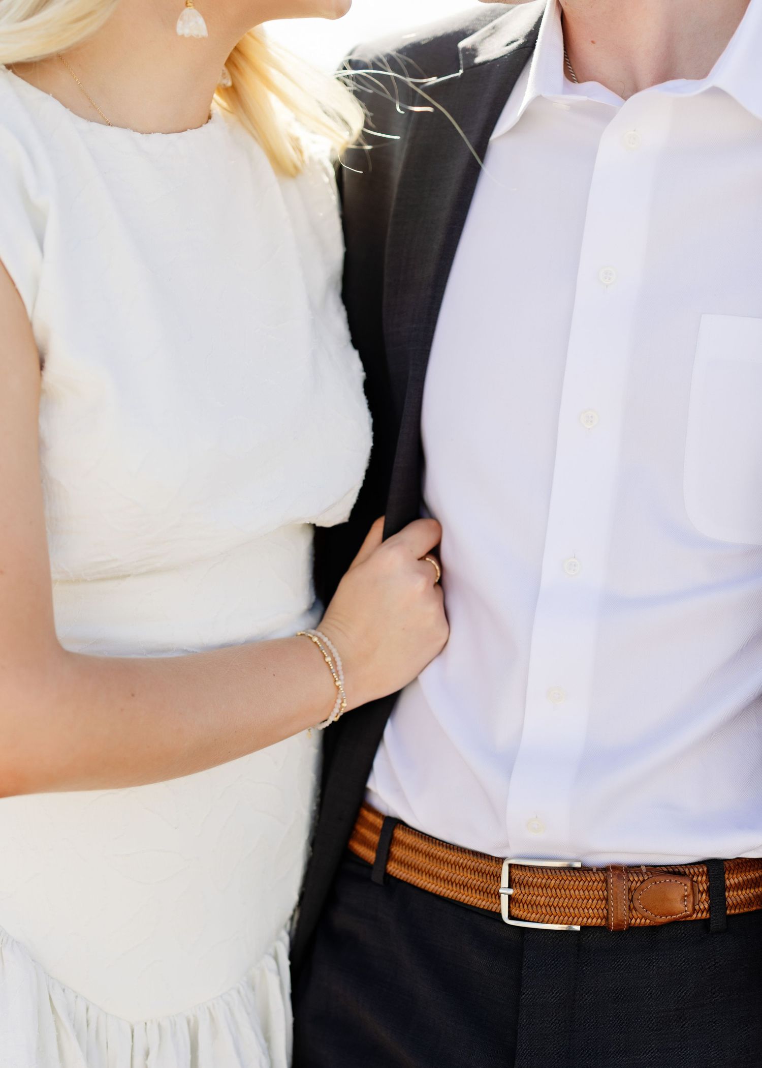 Elegant couple in formal attire with the person wearing a white dress and the other in a black suit.