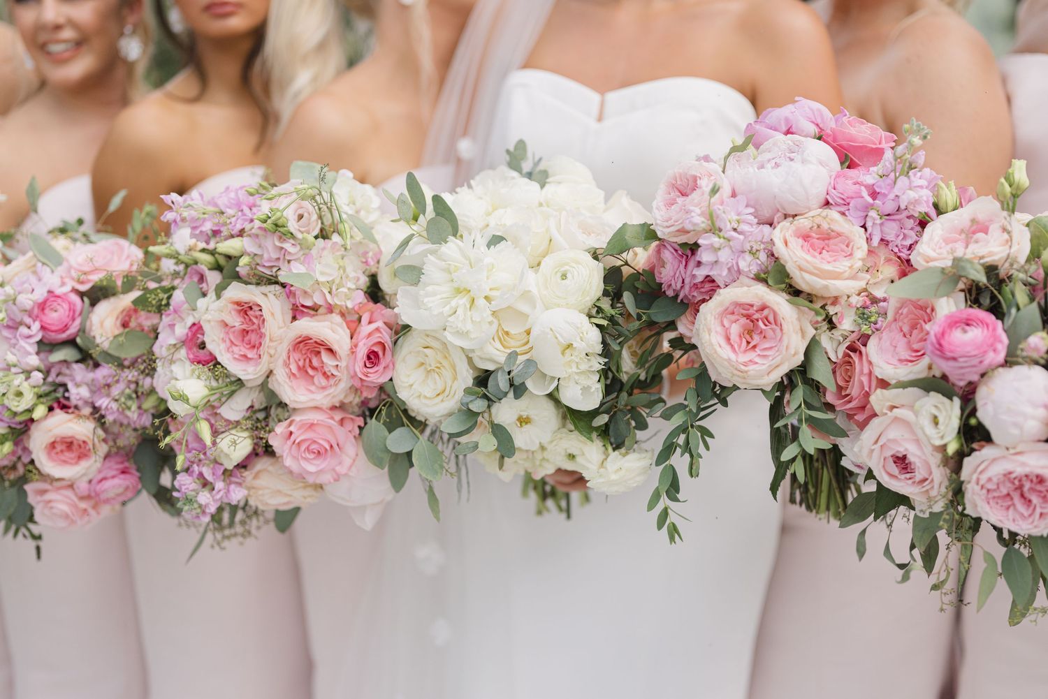 Romantic pink and white garden rose floral arrangements with trailing greenery.
