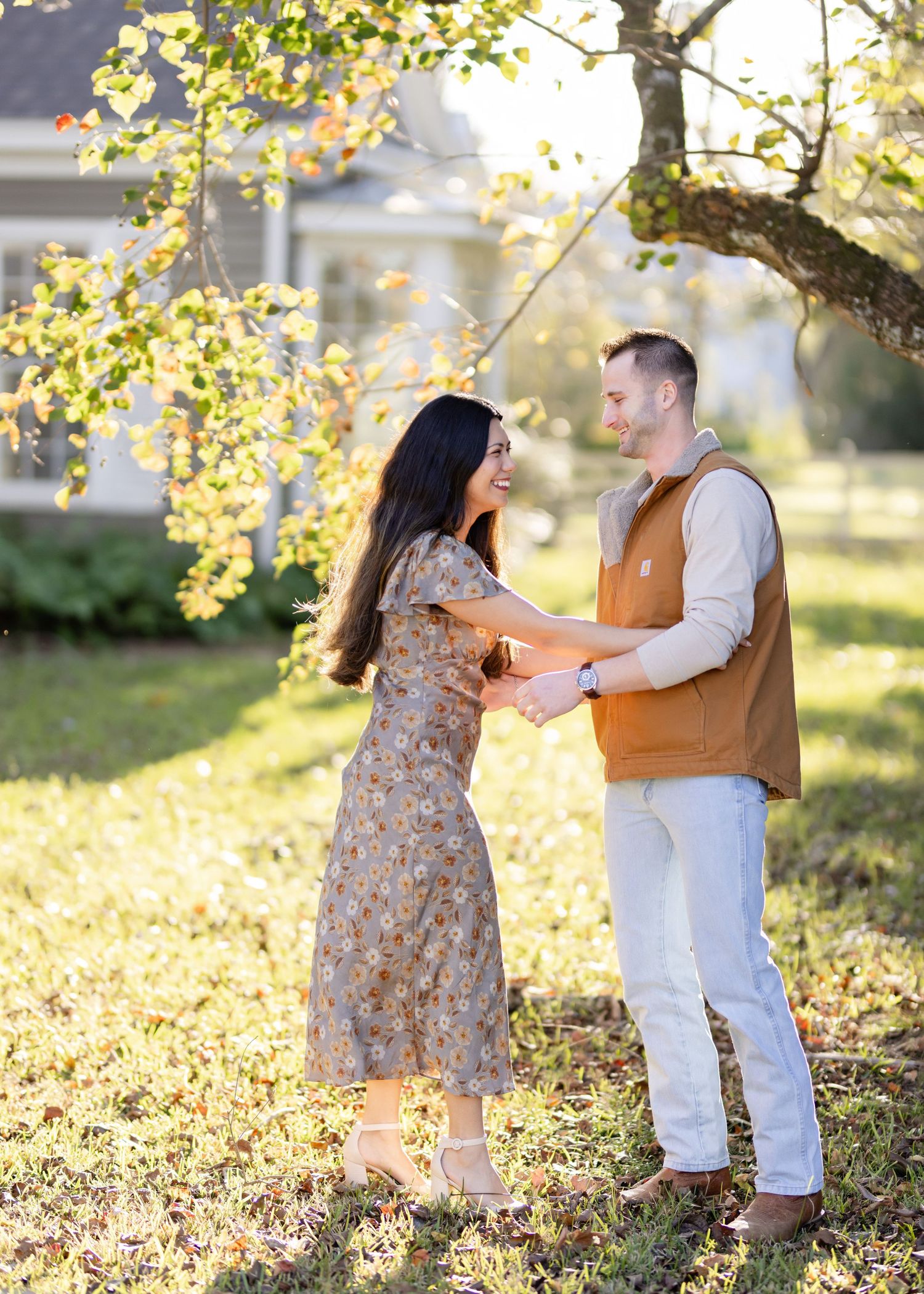 Dancing couple spins together in golden sunlight under autumn trees.