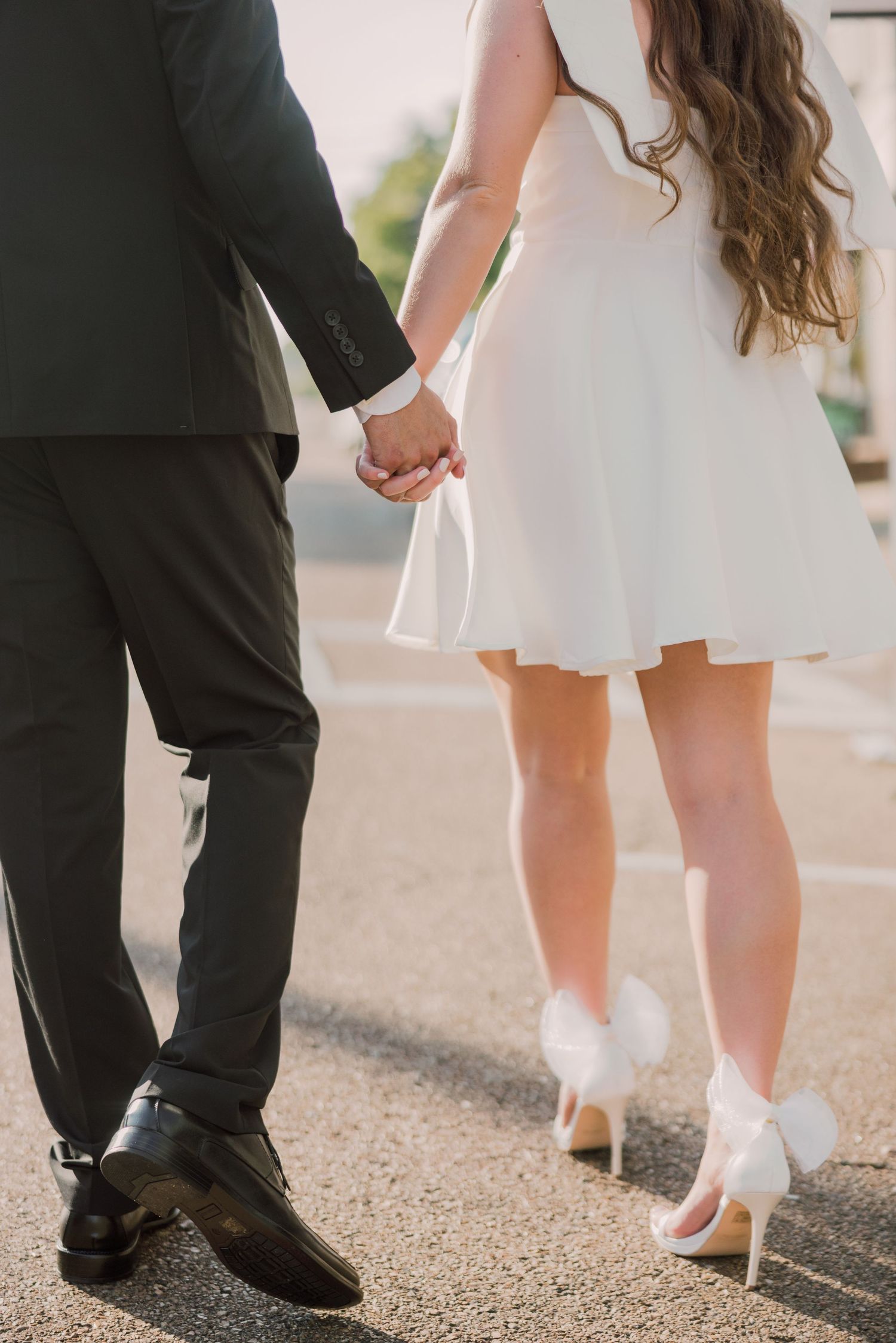 Close-up of formal shoes and dress hemline during an outdoor photoshoot.