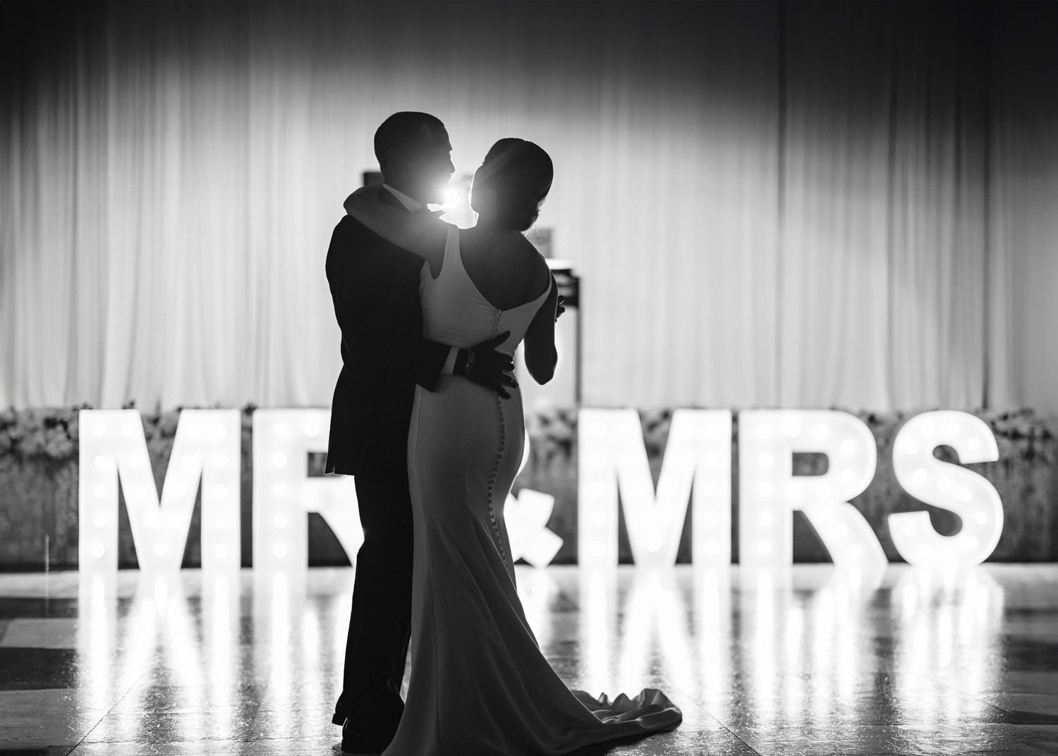Black and white silhouettes of dancing couple with 'Mr & Mrs' text overlay at wedding reception.