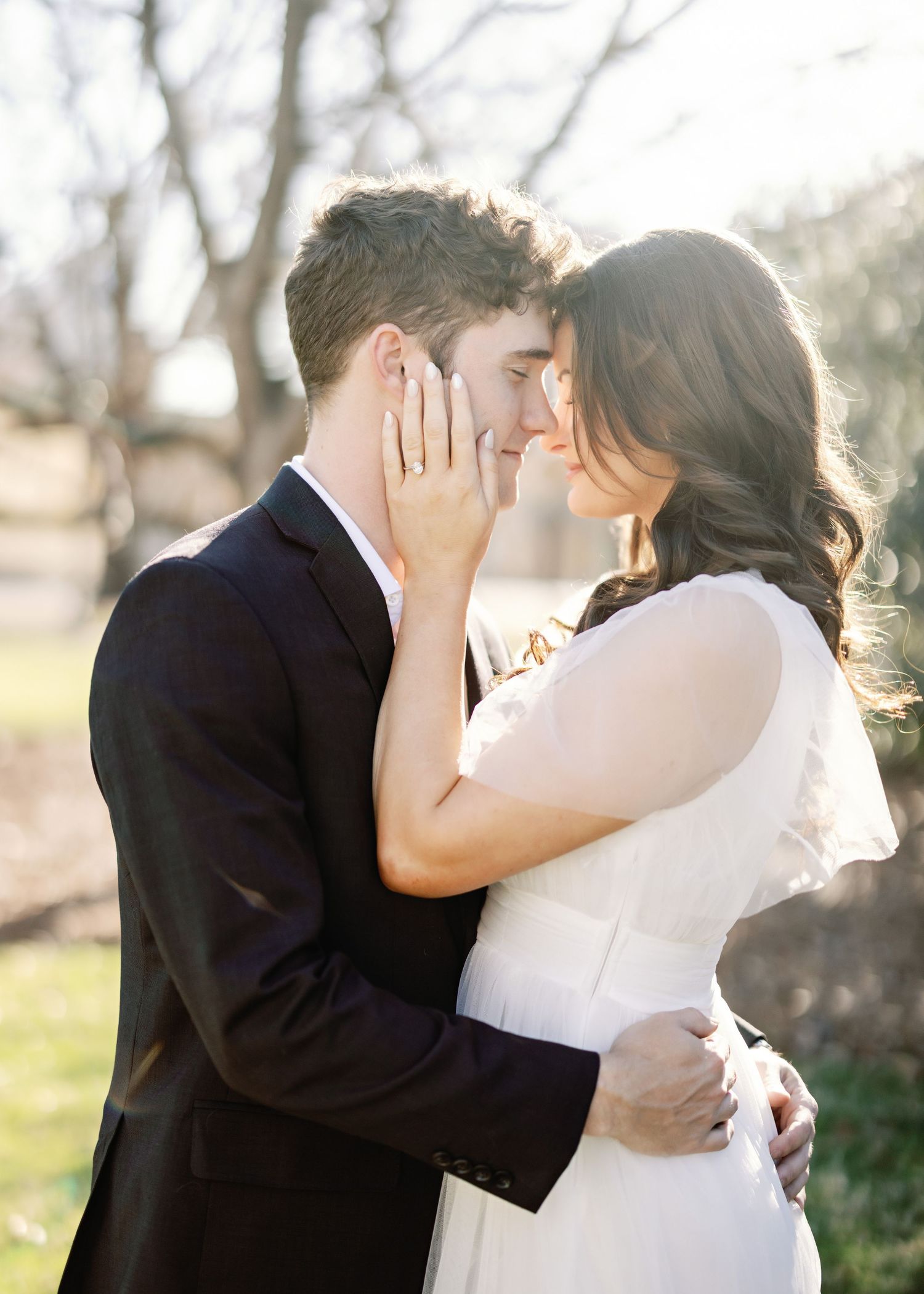An intimate moment between a couple in formal wear outdoors.