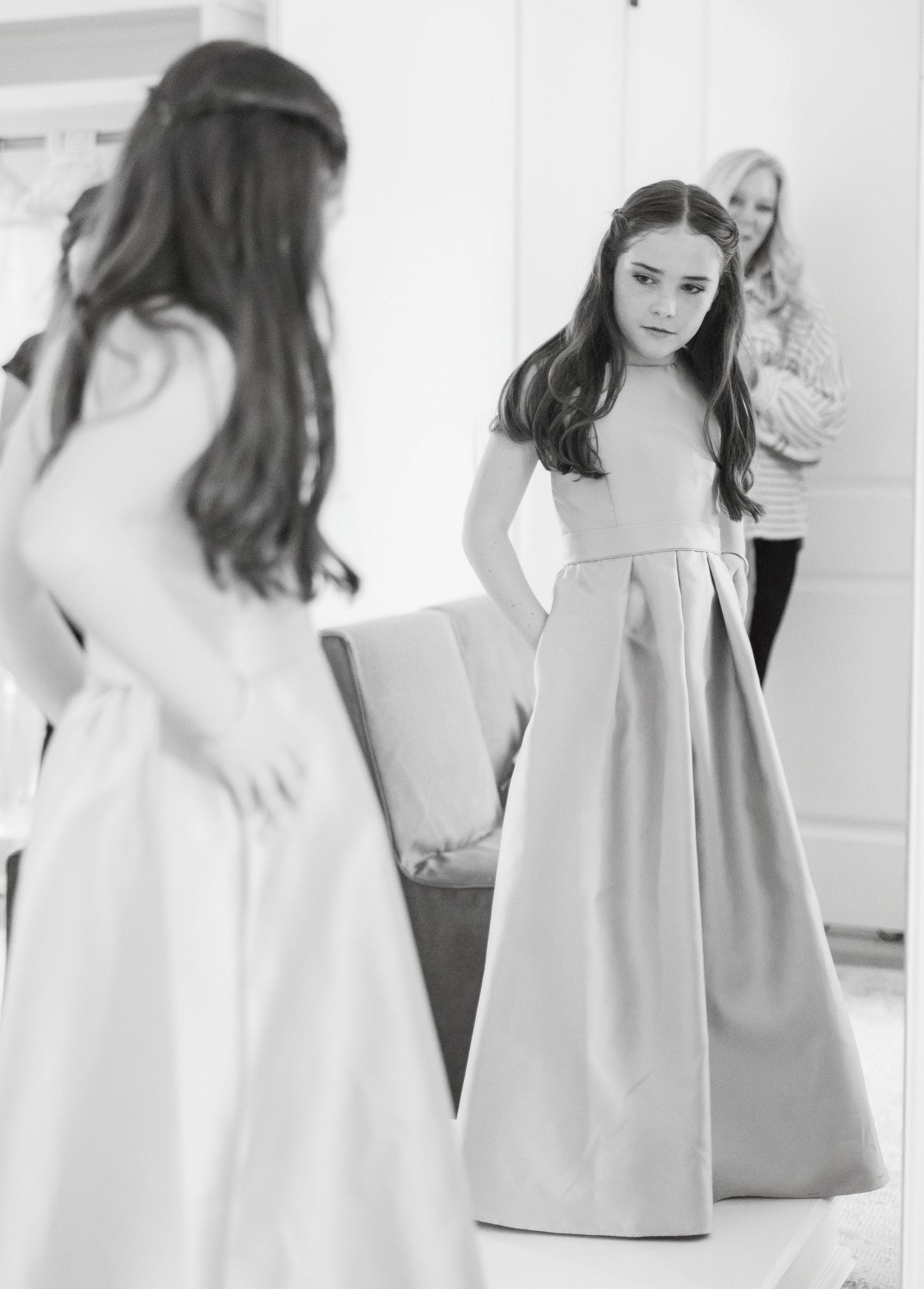 Black and white fashion photo series showing a woman in a light-colored dress posing against a white background.