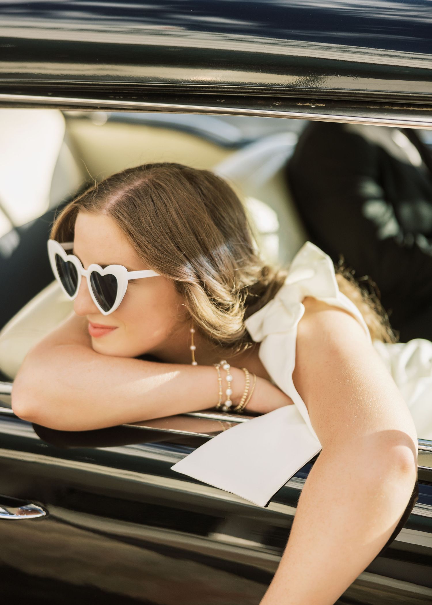 Retro-inspired photoshoot with sunglasses and vintage car details.