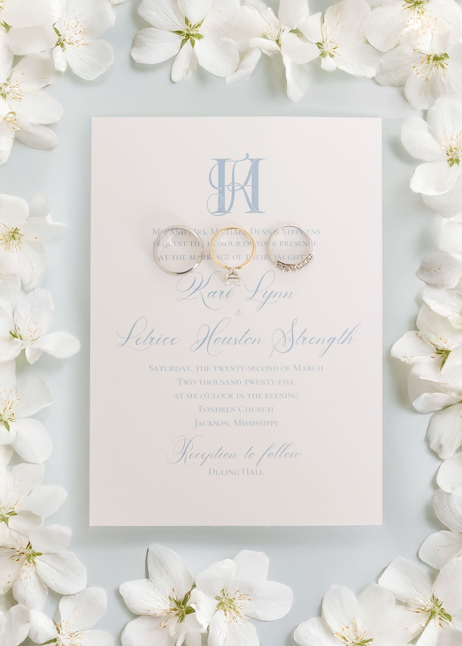 Elegant wedding invitation suite with monogram and floral details on white background.