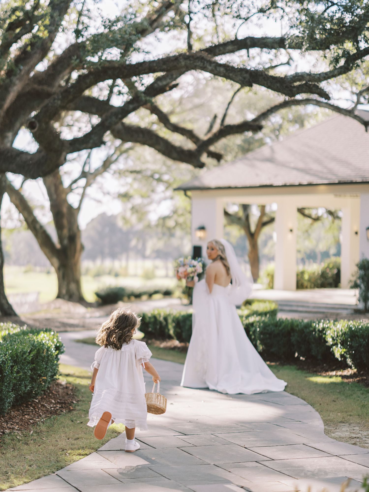 A sequence of dreamy outdoor portraits showing movement and twirling in a white dress under majestic oak trees.
