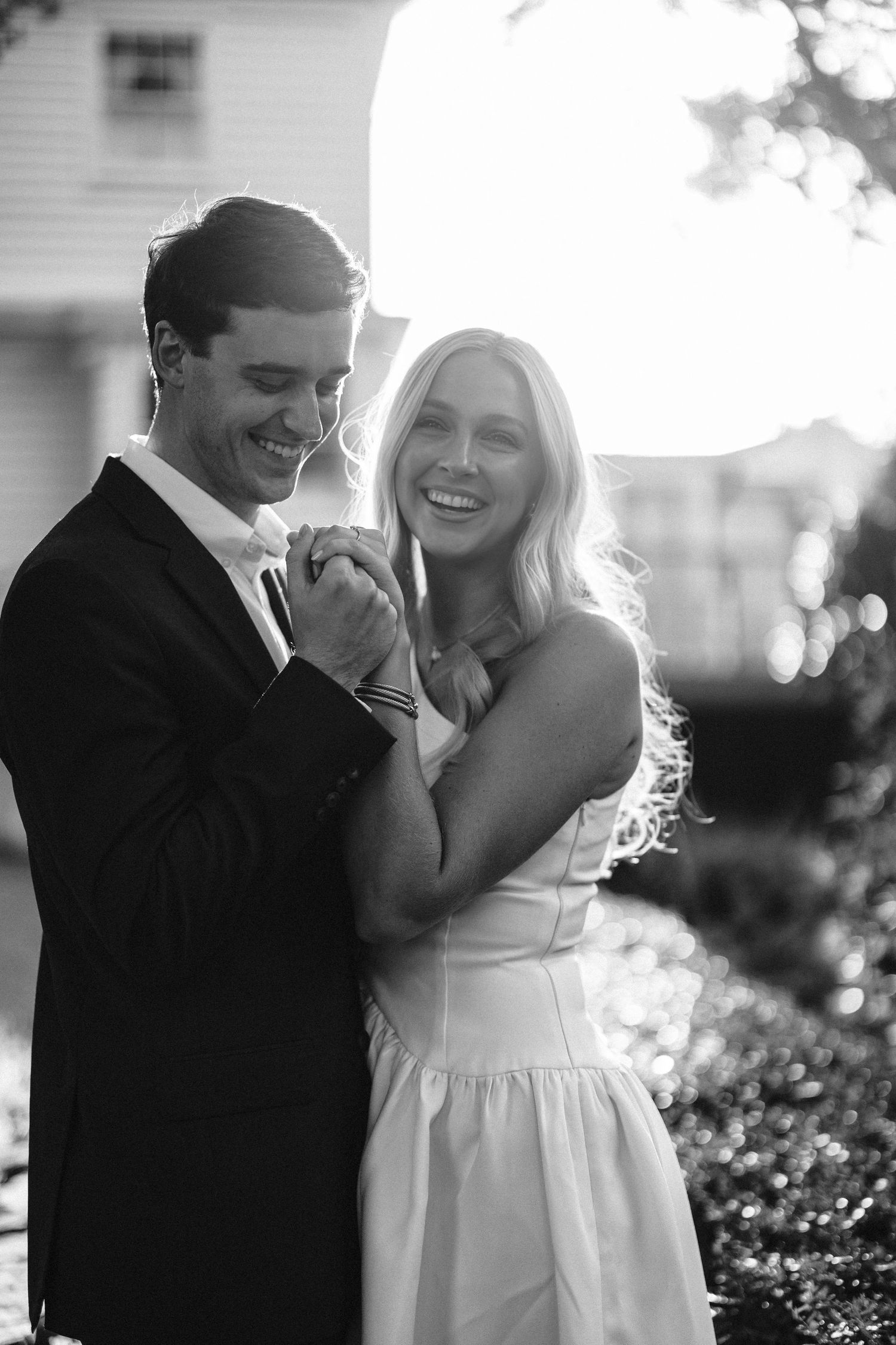 Black and white candid moments shared between couple in garden setting.