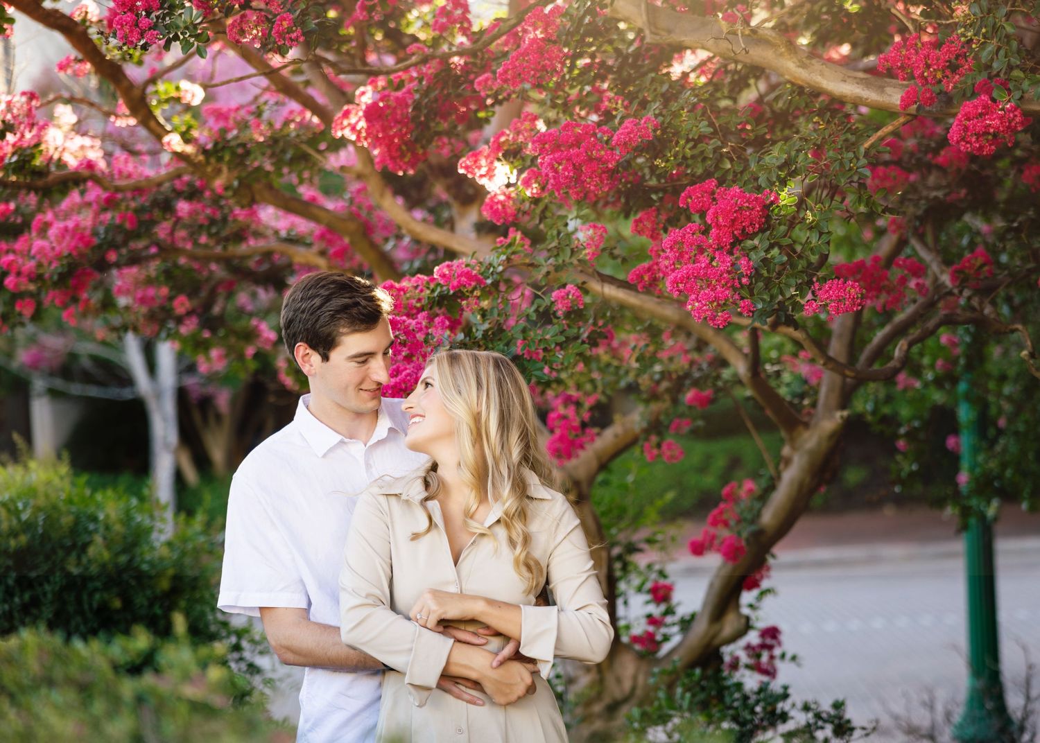 Intimate moment shared under blooming pink bougainvillea flowers.