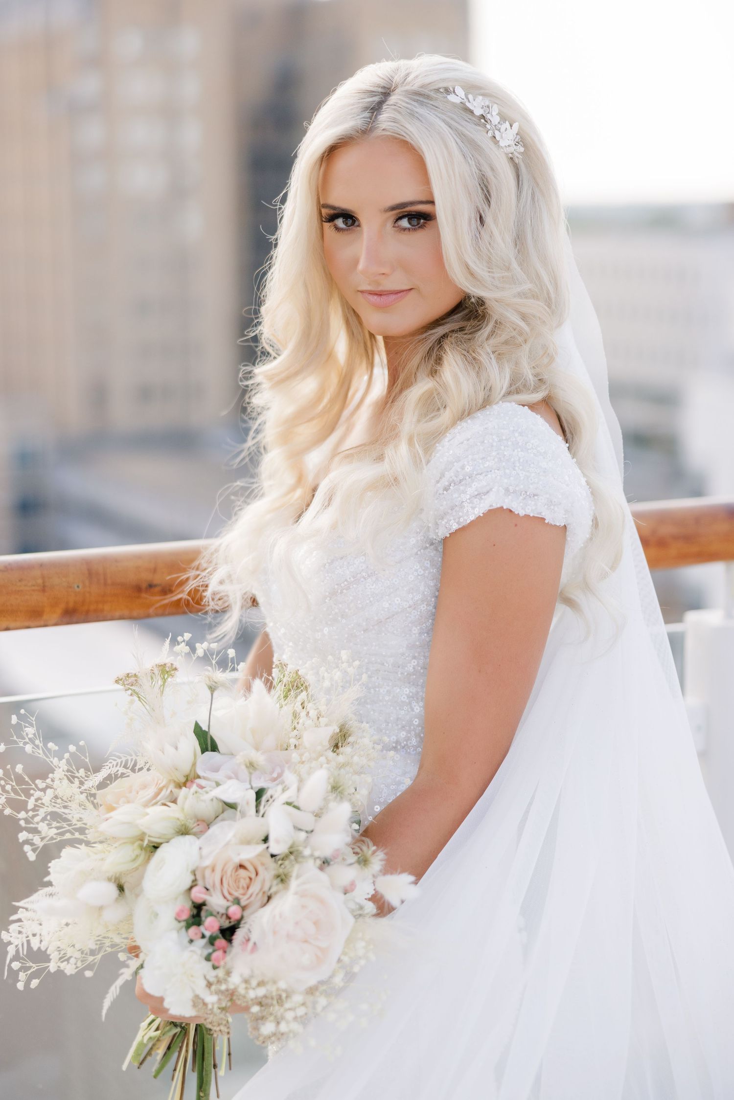 Bridal portrait series featuring white lace gown and elegant bouquet on urban rooftop setting.