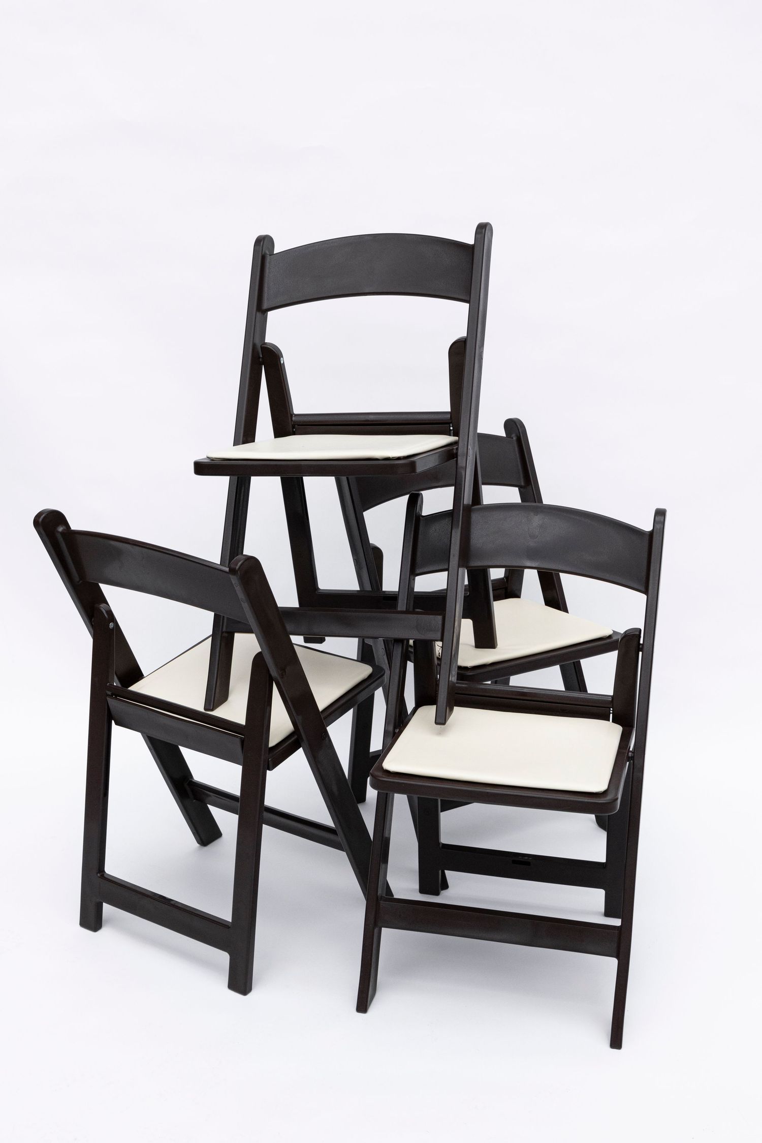 Black wooden folding chairs with white cushions photographed from different angles.