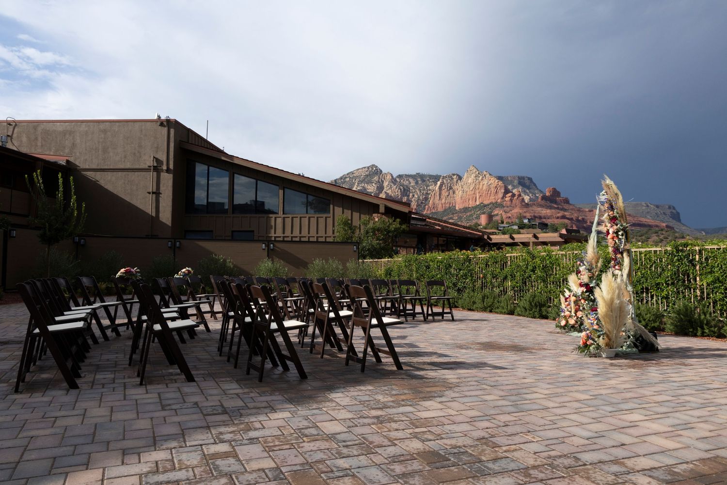 Outdoor patio seating area with mountain views and stone tiled flooring at a winery or restaurant.