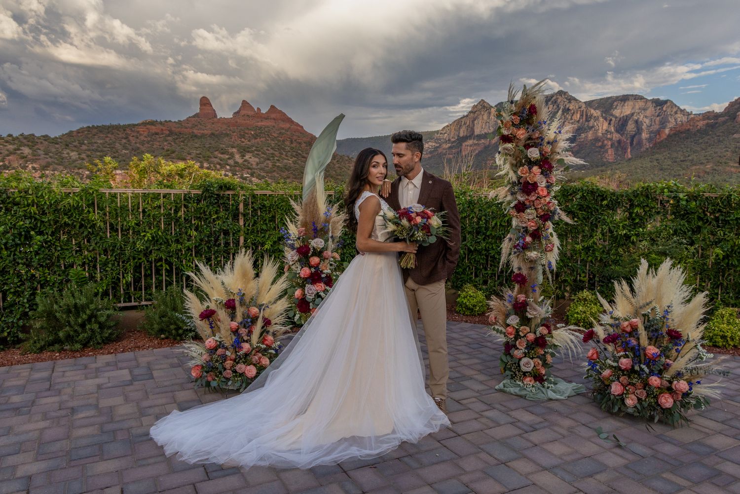 Wedding ceremony setup with floral arrangements and mountain backdrop at sunset in Arizona desert landscape.