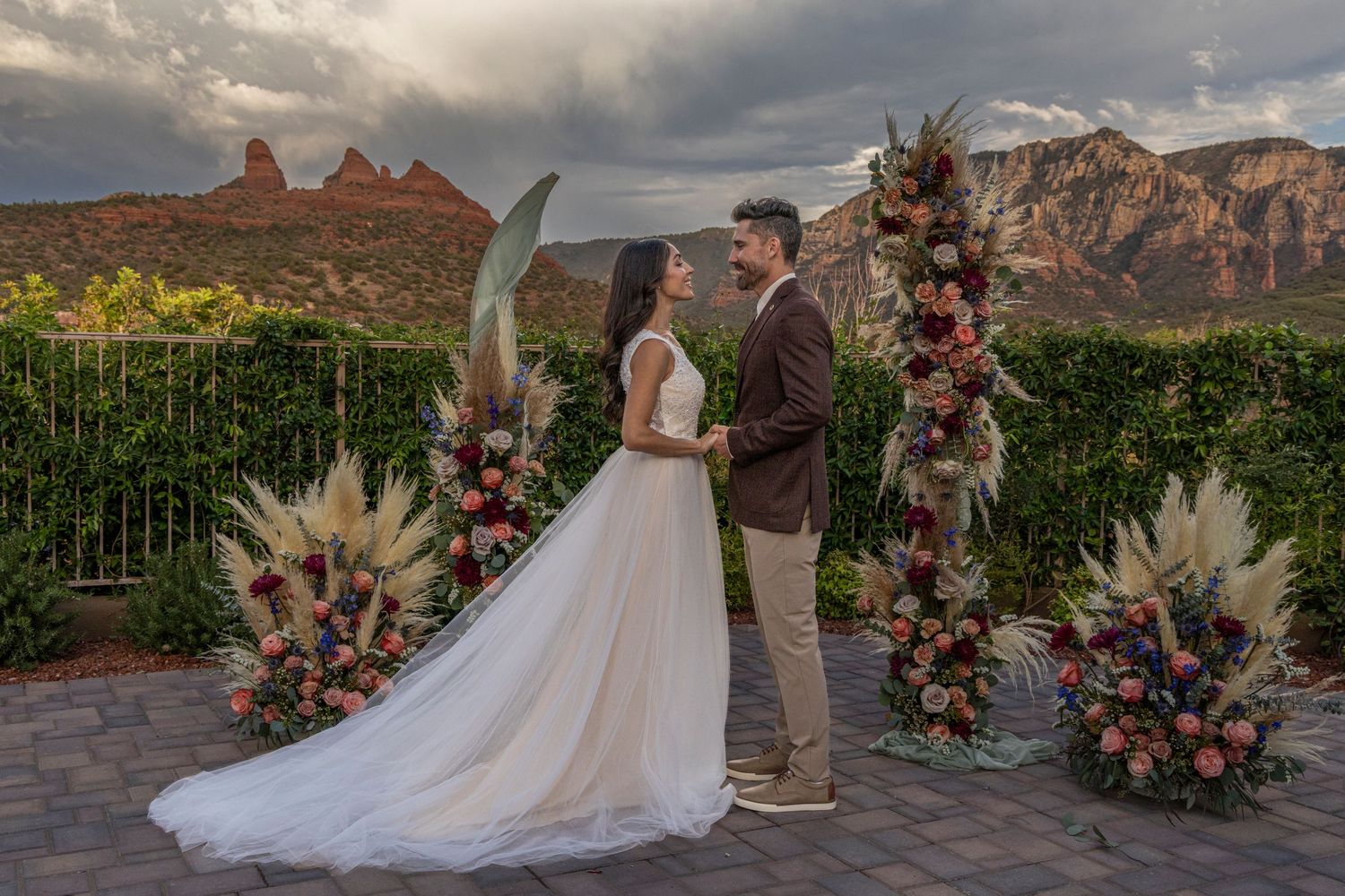 A romantic wedding ceremony takes place against the backdrop of majestic red rock formations in Sedona, Arizona.