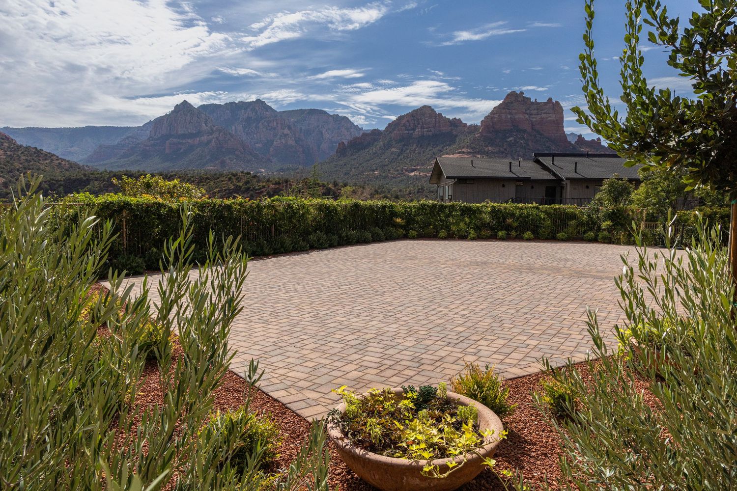 Panoramic mountain landscape with desert vegetation and modern homes nestled against rugged peaks under blue skies.