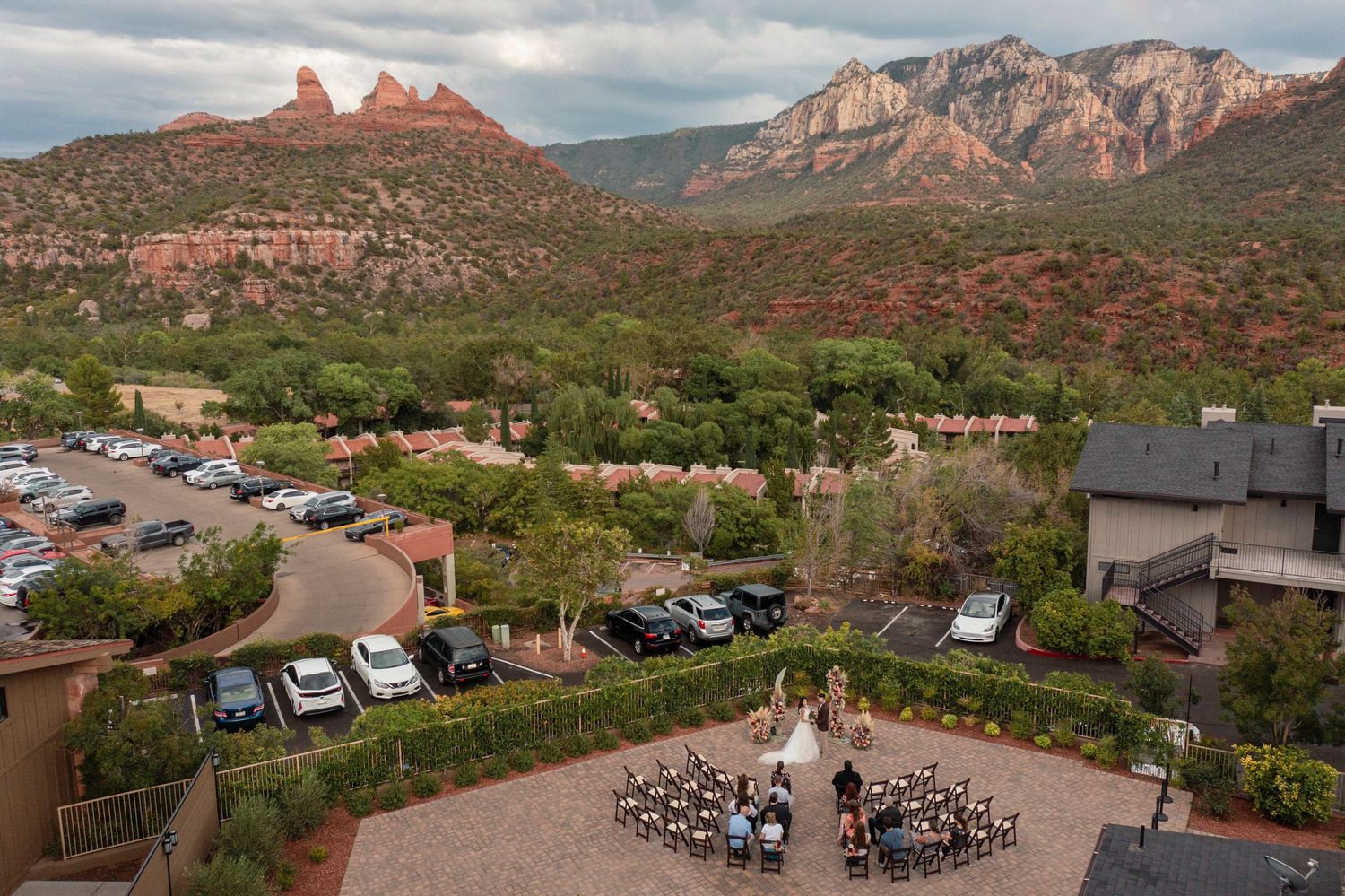 Panoramic view of red rock formations and desert landscape in Sedona, Arizona with dramatic cloudy sky overhead.