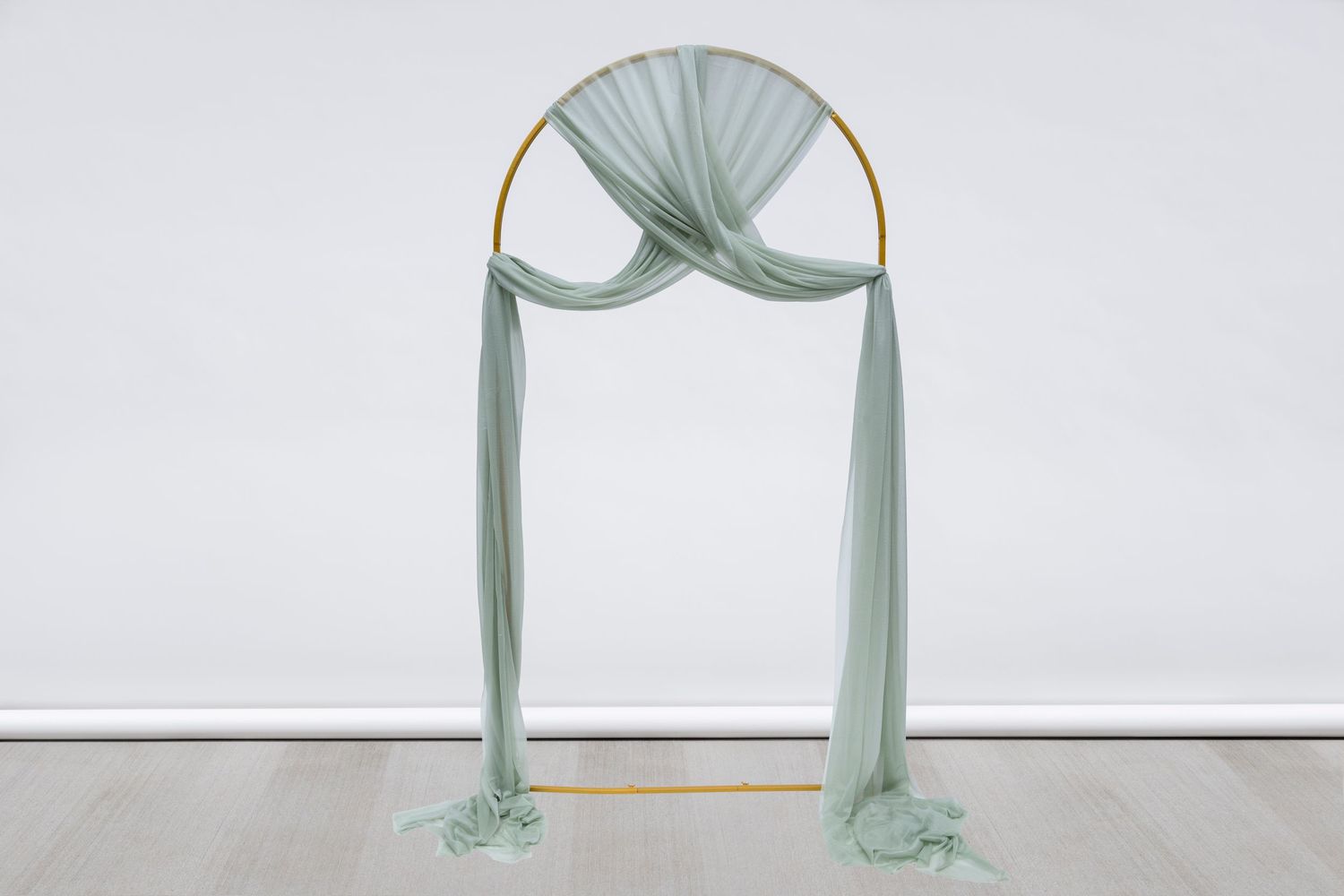 Soft mint green fabric arch backdrop arranged for wedding ceremony decoration.