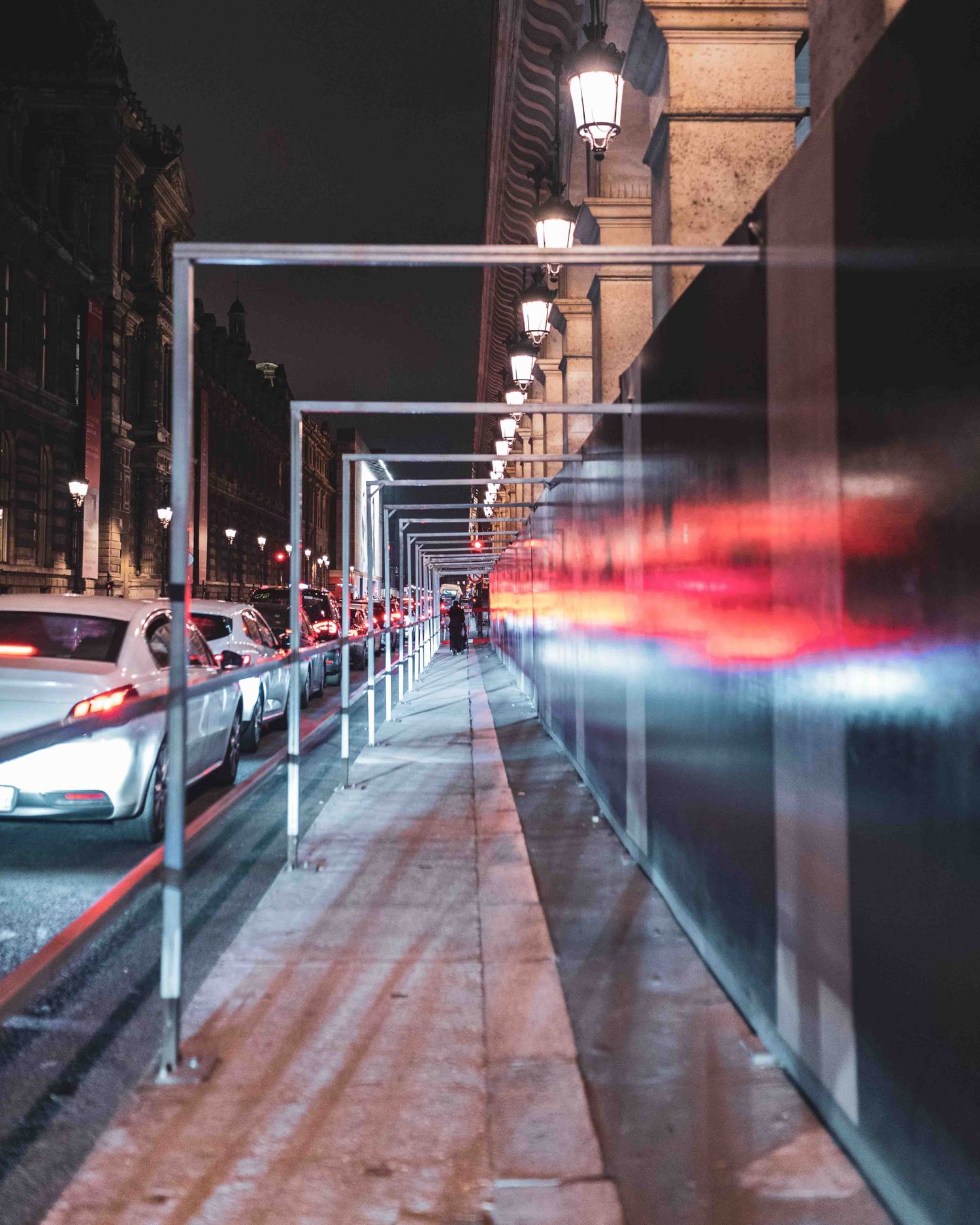 Urban covered walkway at night with modern lighting and red blur effects creating a futuristic city atmosphere.