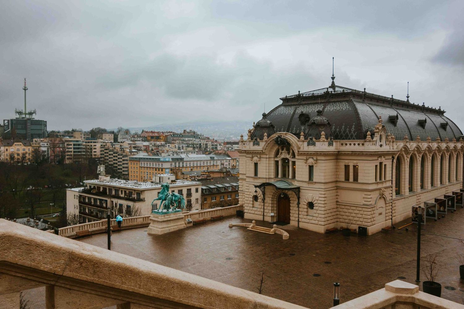 Panoramic view of historic buildings and balconies along a misty European coastline under cloudy skies.