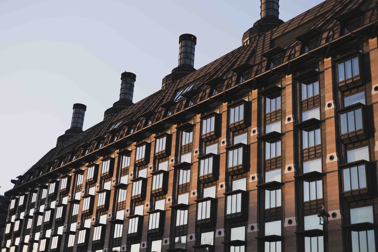Architectural progression showing the same Tudor-style building facade repeating with increasing contrast and shadows against sky.