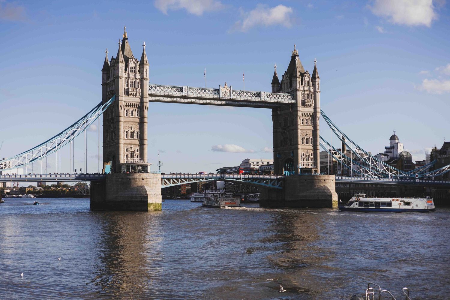 Six sequential photos show the Tower Bridge opening up over the River Thames in London to let boat traffic pass beneath.