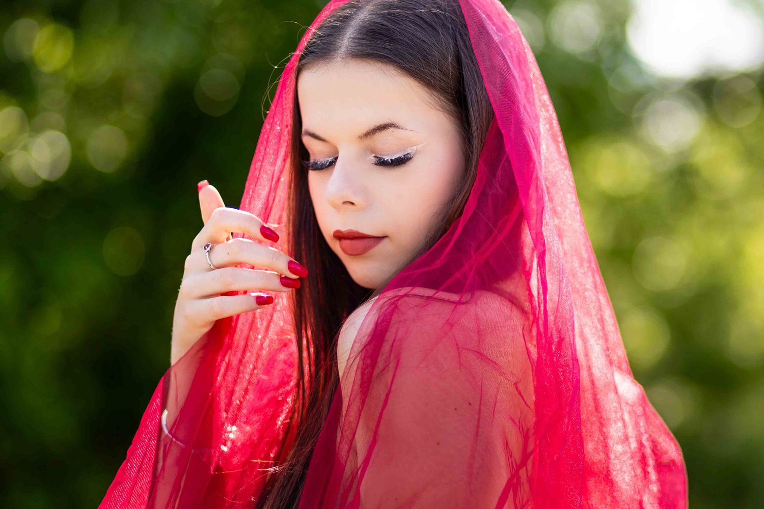 A portrait series with bright pink hair against a natural green bokeh background.