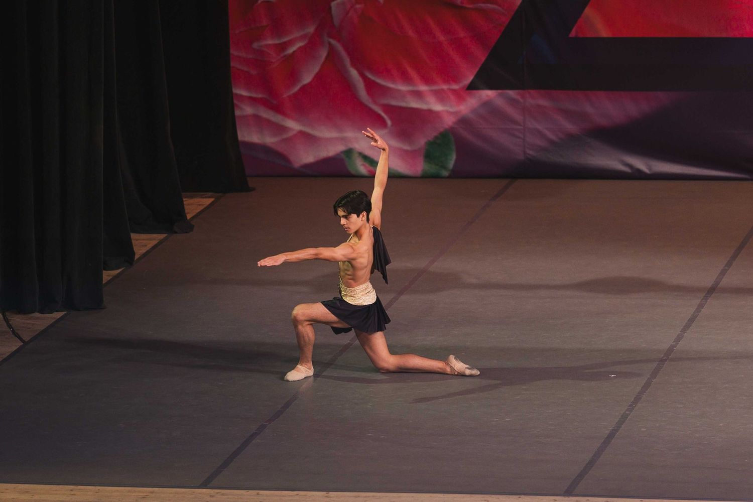 A dynamic series of dance poses shows a performer in black attire moving gracefully across a studio floor in flowing sequence.