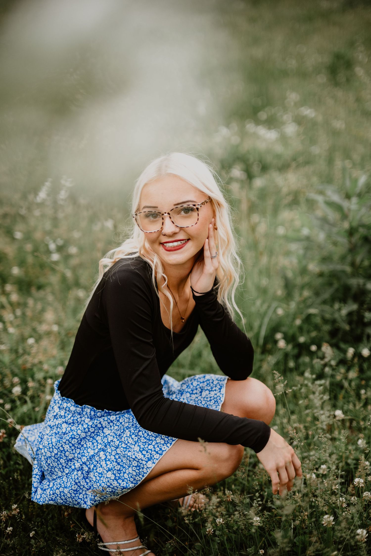 A playful outdoor portrait in a wildflower meadow featuring black and blue outfit combinations.