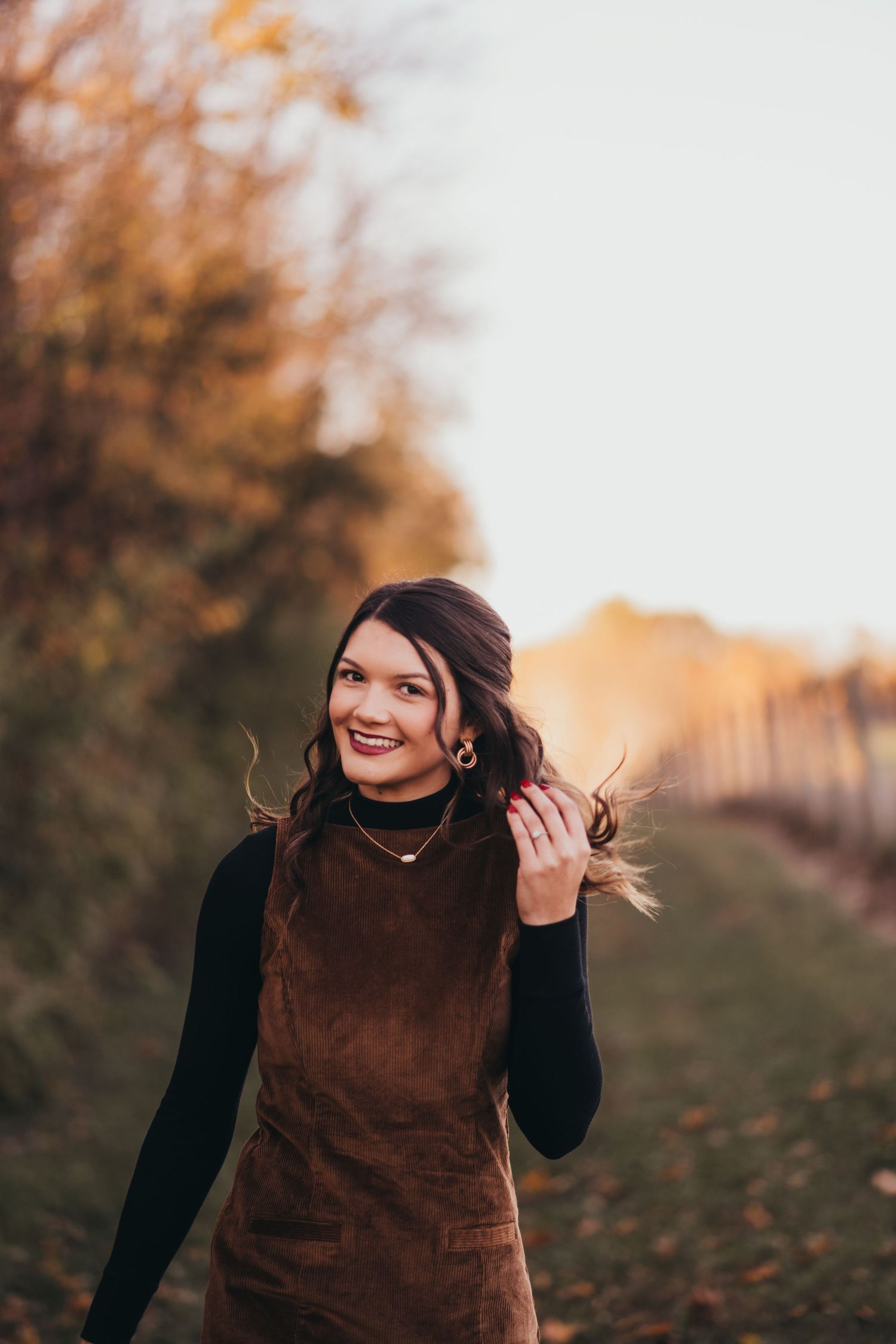 An autumn portrait session with warm brown tones and natural lighting at golden hour.