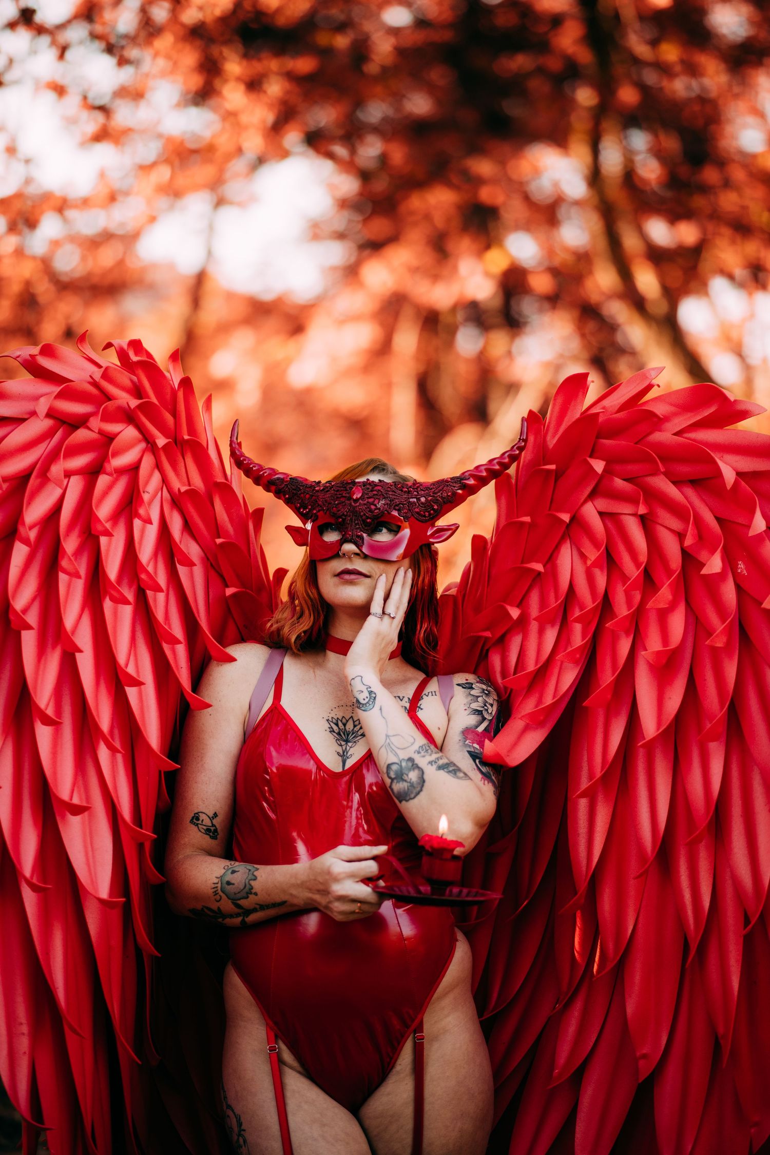Artistic portrait series featuring red paper wings against warm autumn bokeh background. Vanceburg Ky