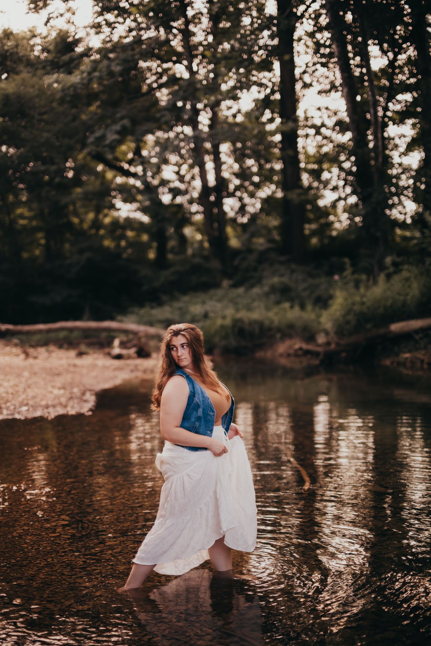 A romantic water photoshoot featuring white dress and denim elements in a tranquil pond setting.