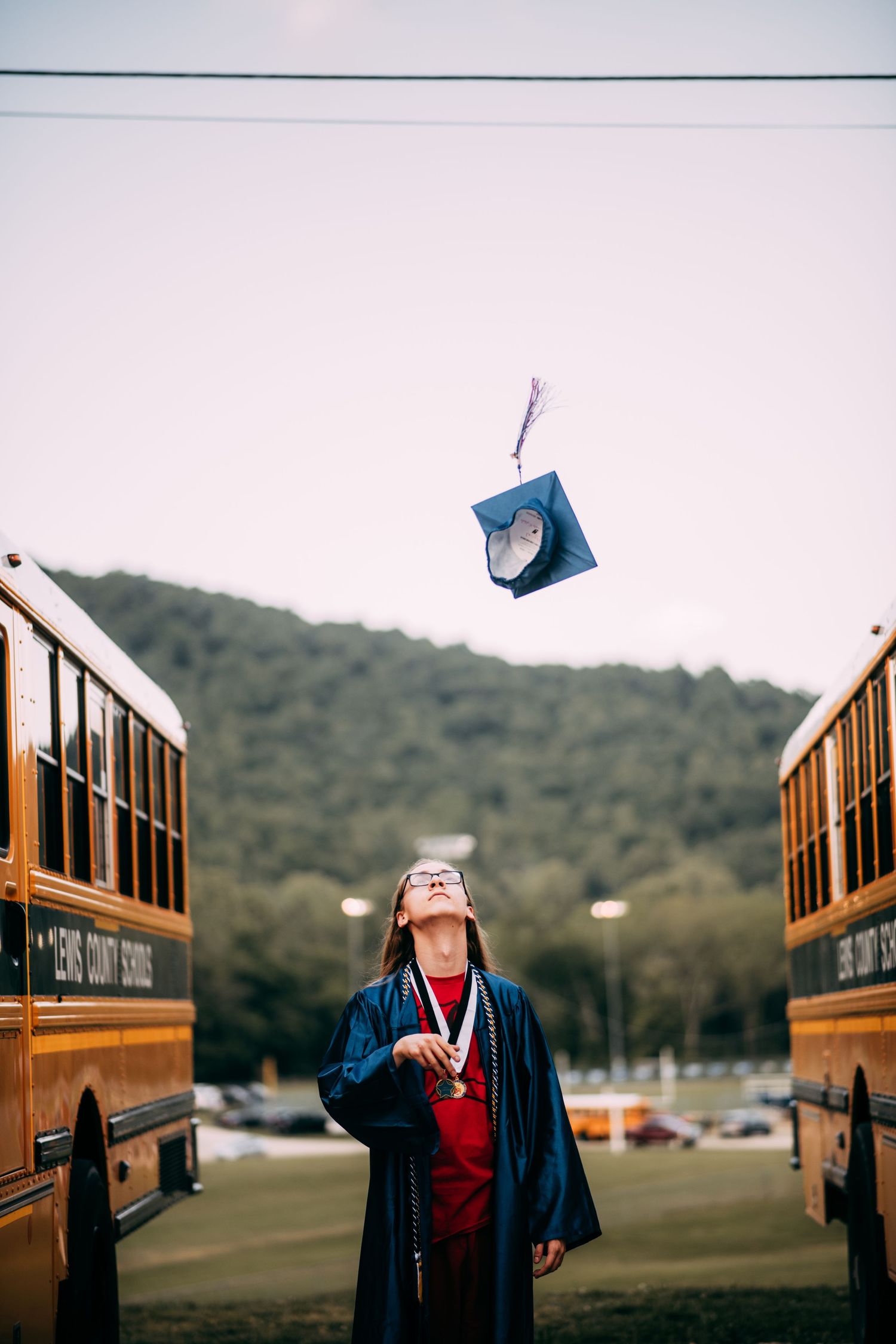 A graduation photoshoot sequence showing a cap being tossed into the air against a mountain backdrop.