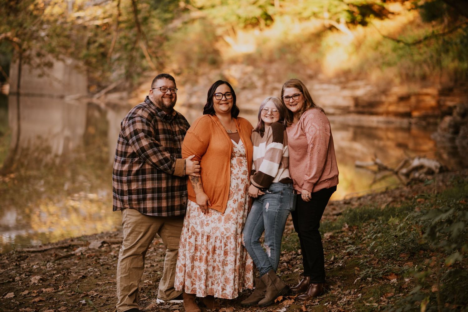 Family portrait session in autumn forest setting with warm golden sunlight filtering through trees. Vanceburg Ky