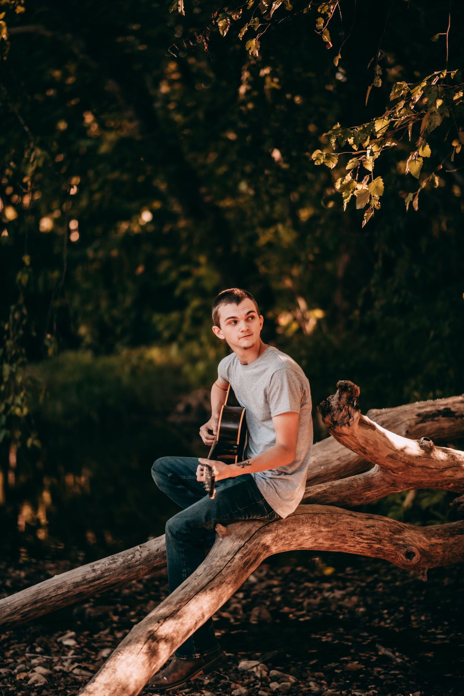 A casual outdoor portrait session on a fallen tree log during golden hour.