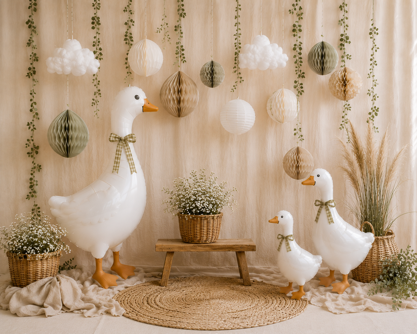 Charming nursery photo backdrop featuring white duck figures, honeycomb balls, and hanging greenery.