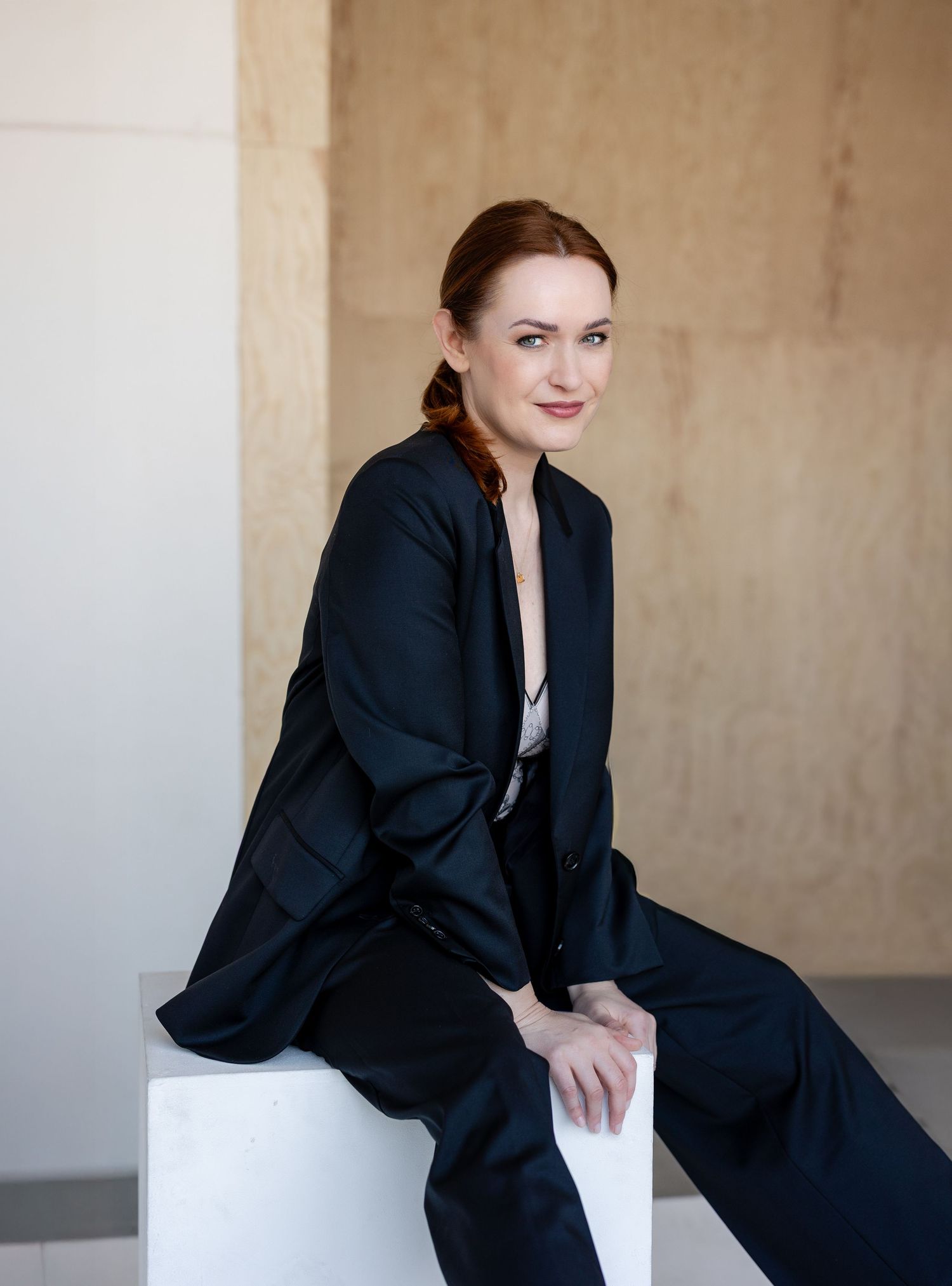 A sequence of professional portraits showing someone in a black blazer against a neutral background.