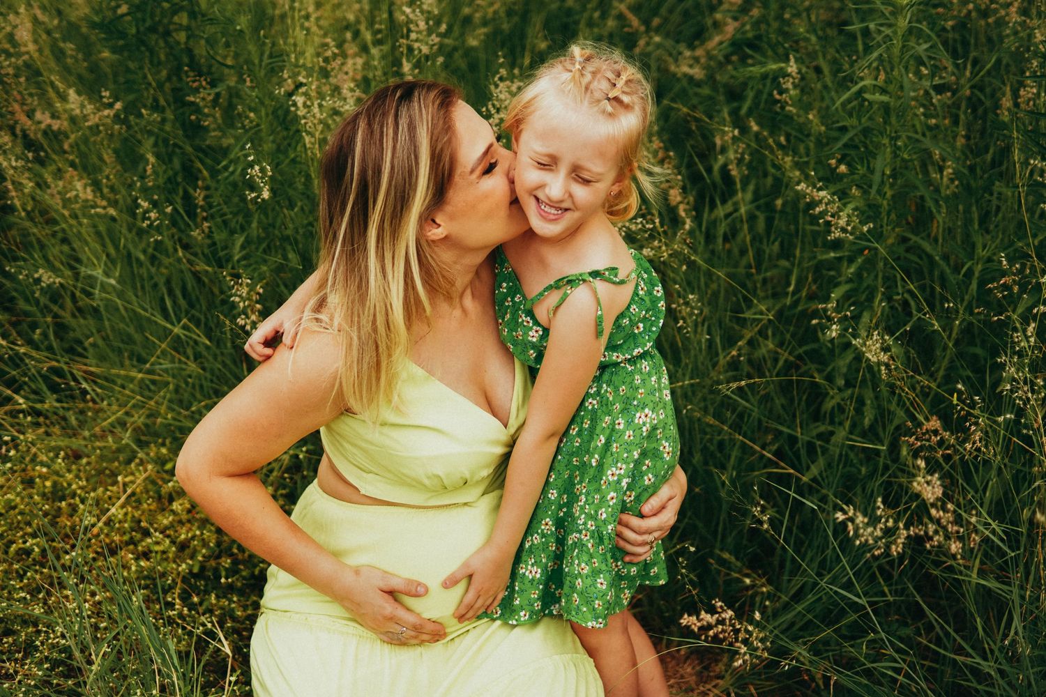 Mother and child sharing joyful moment in green summer field.