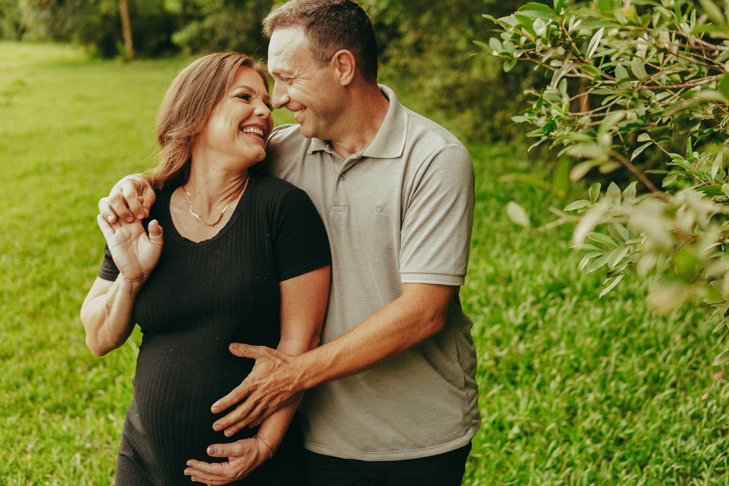 Intimate outdoor photography session featuring natural poses and genuine moments in a green setting.
