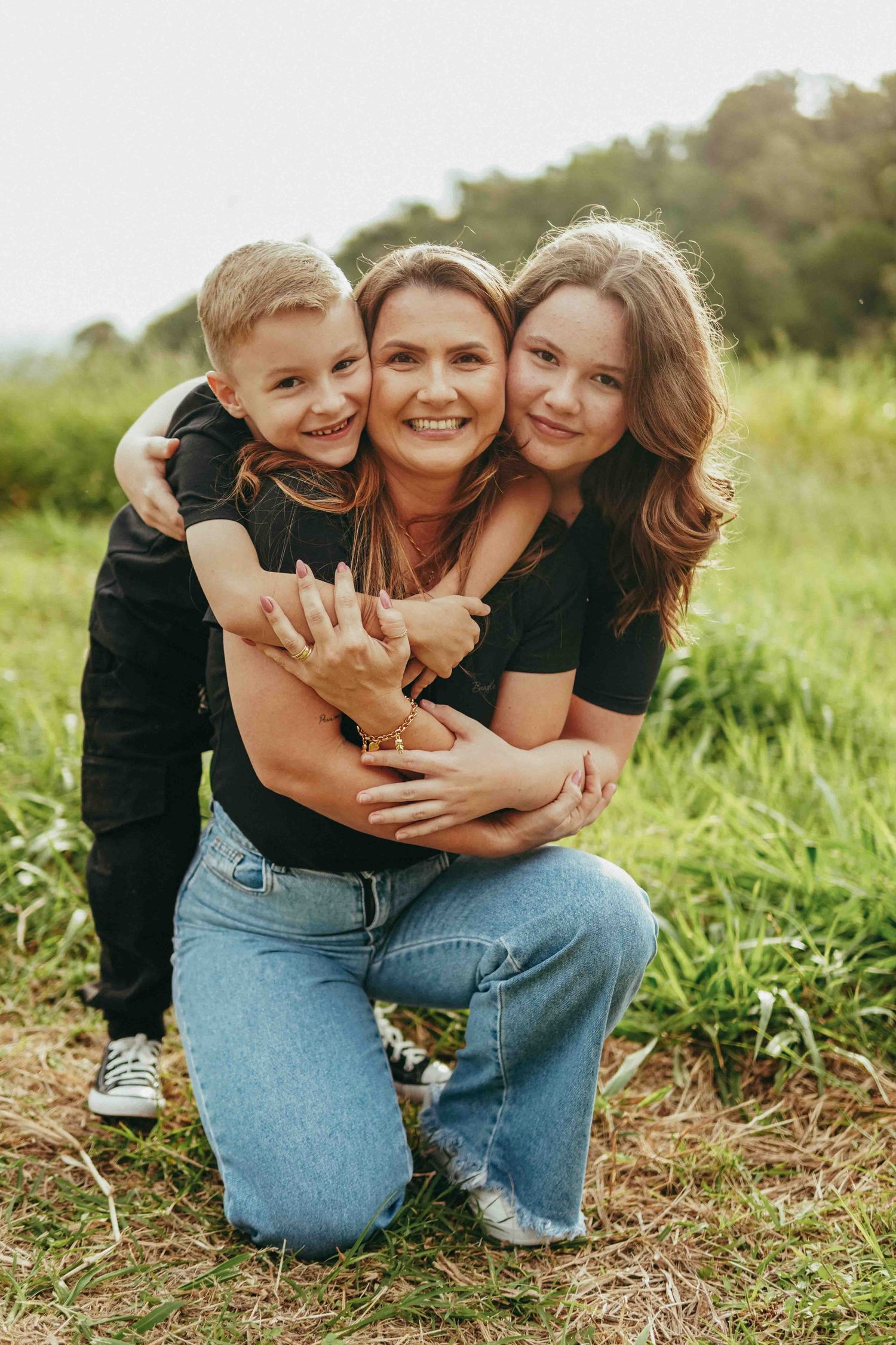 Candid moments of affection and laughter captured on a sunny day in a grassy field.