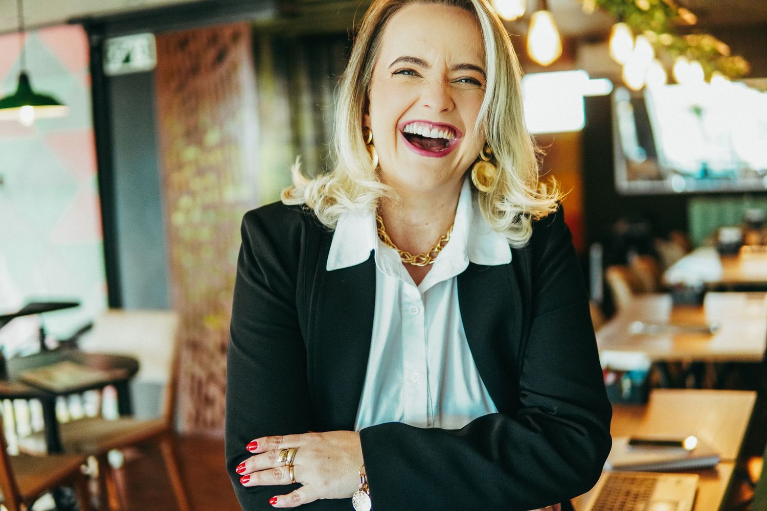 Business professionals sharing a laugh during a casual meeting at a restaurant.