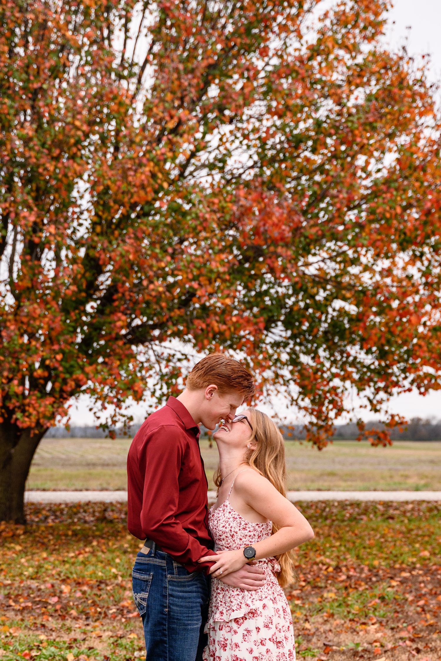 A couple leaning in for a kiss during an autumn engagement session.