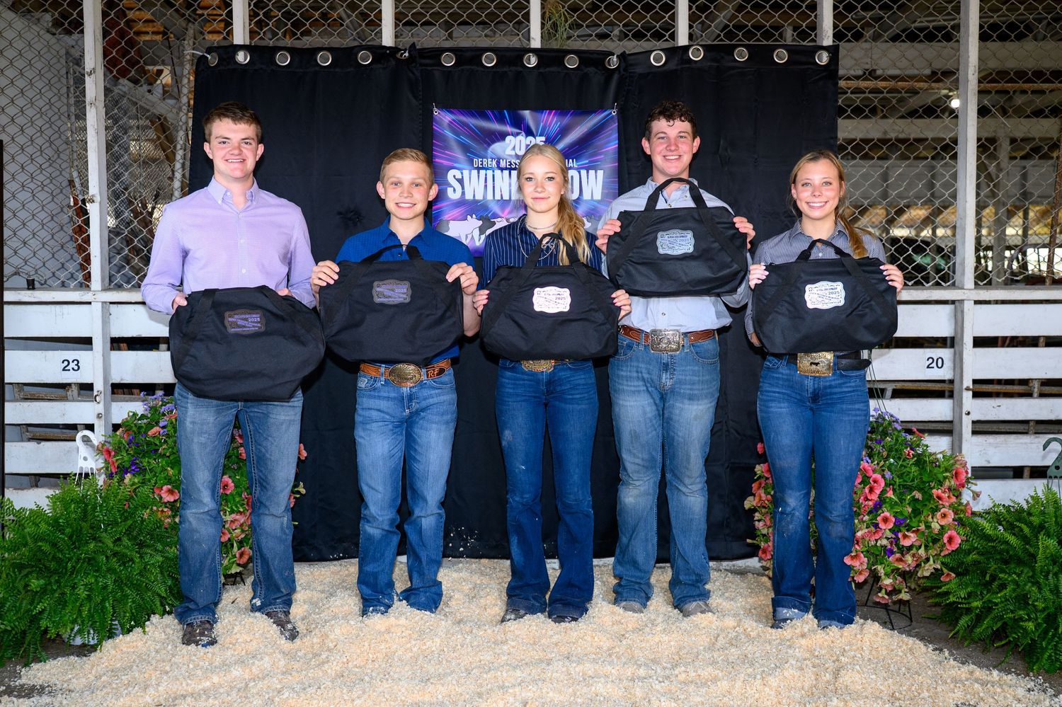 A group of senior showmanship winners posing for a photo at the backdrop with their awards.