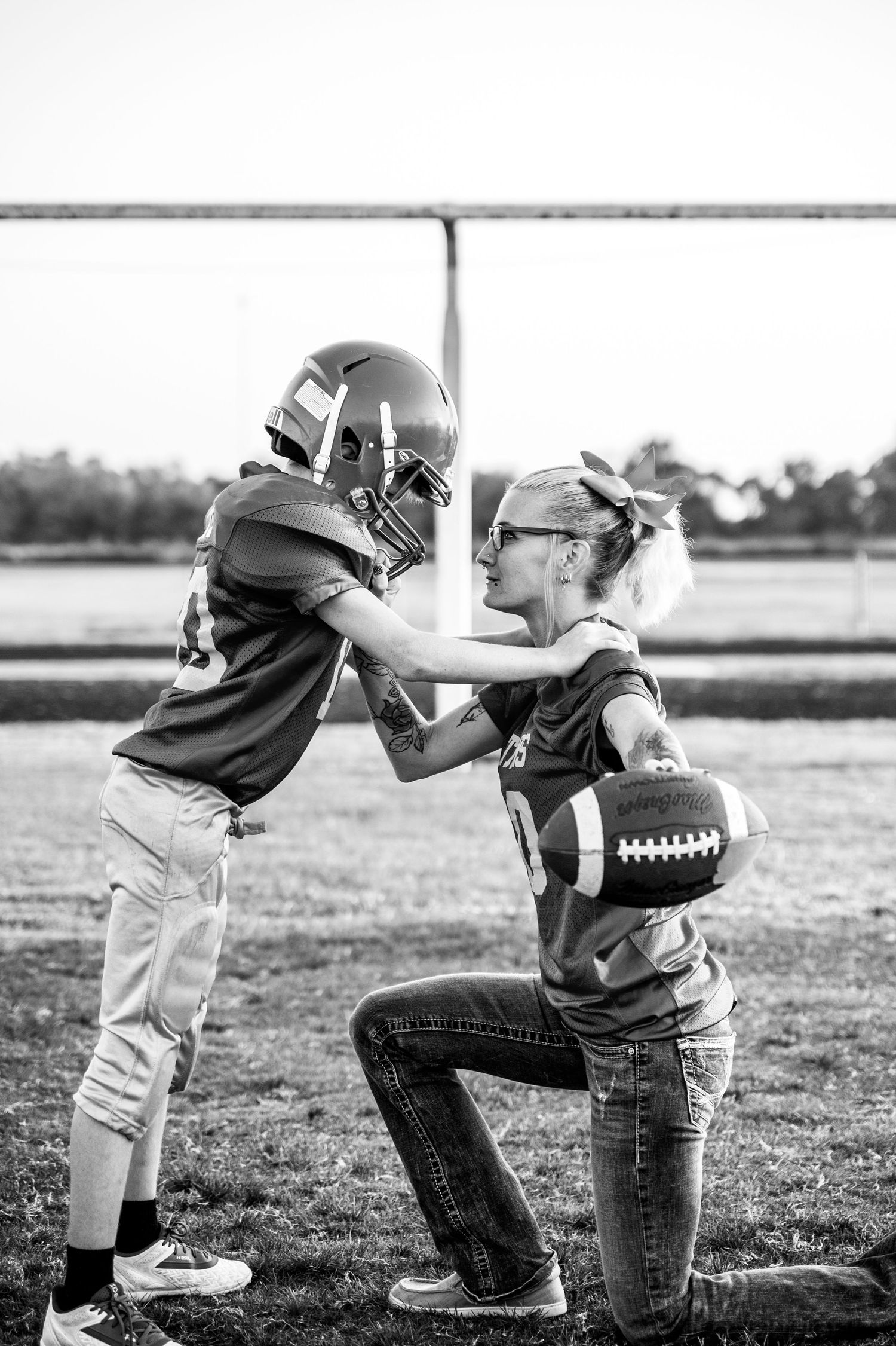 A mom and her son on a football field, capturing the moment before her son moves to junior high football.
