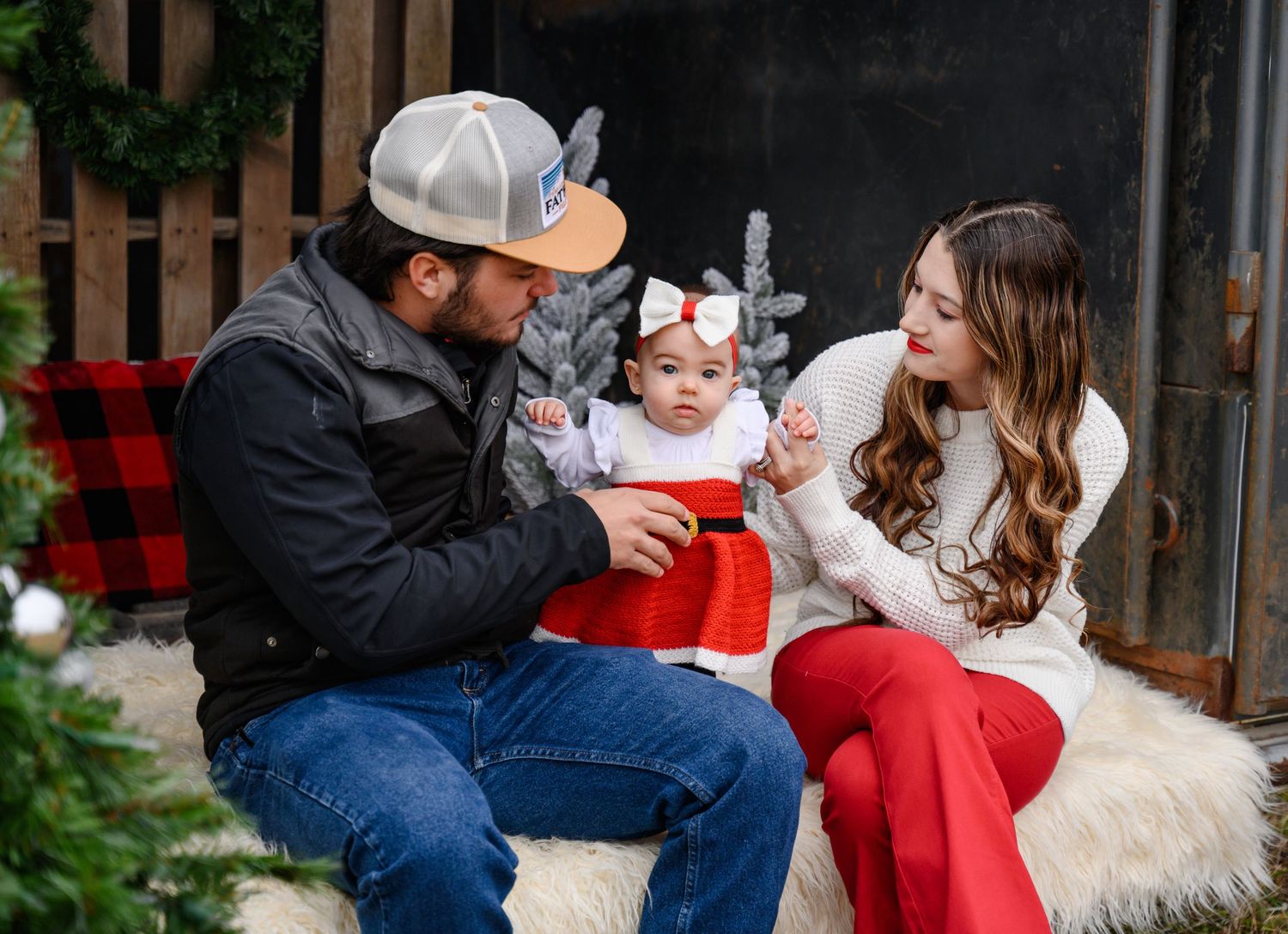 A family sitting together in a trailer looking at each other during their rustic Christmas mini session.