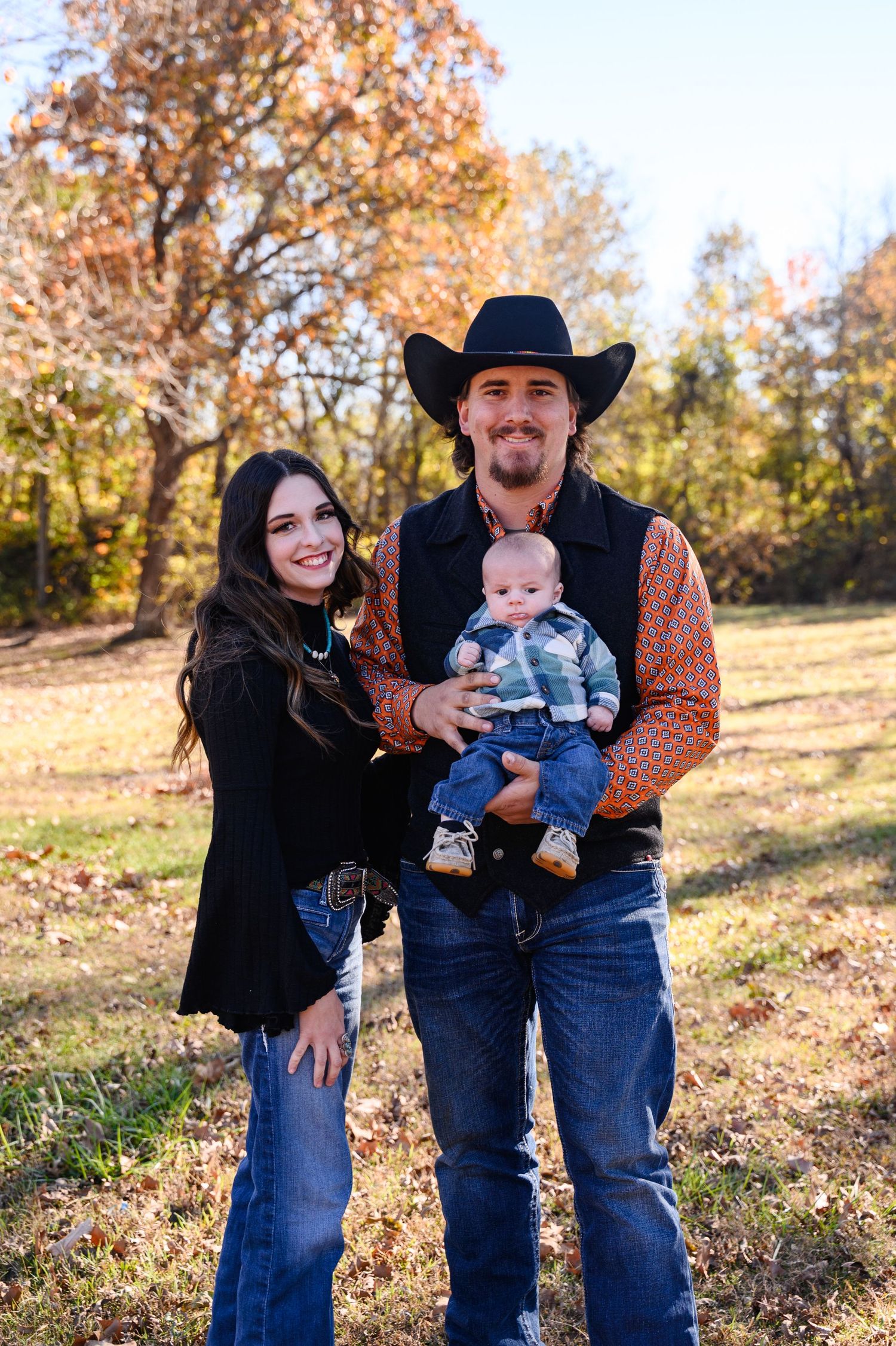 Family in western attire poses together in a field in Southeast Kansas.