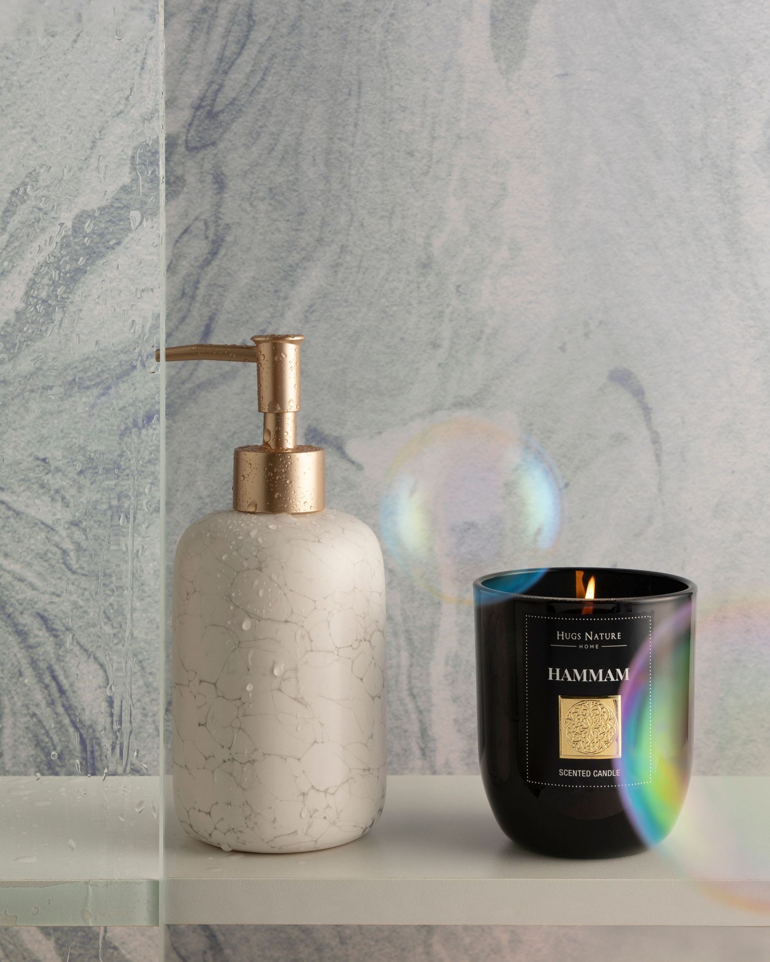 Minimalist concrete candle holders and black candle jars arranged against a marble backdrop with prismatic light effects.